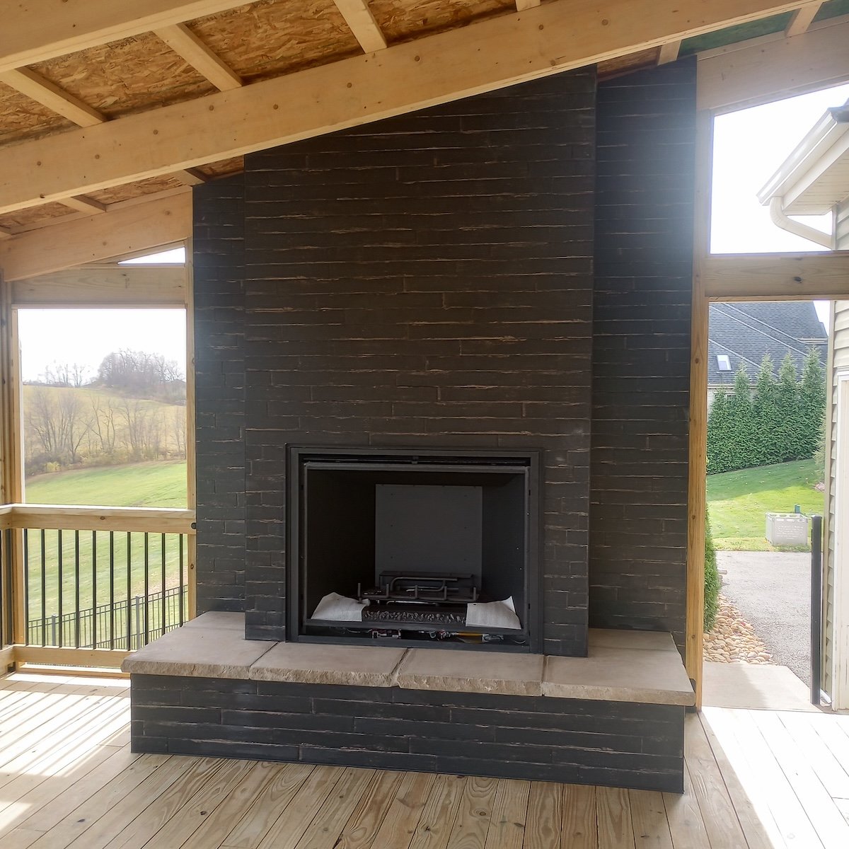 image of a black brick fireplace in a covered patio deck