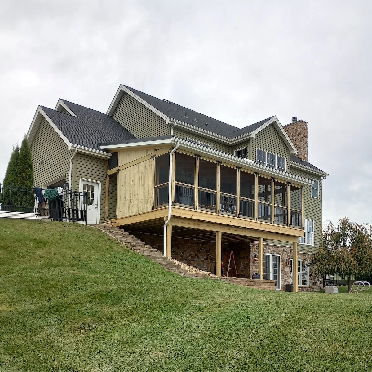 Image of a the rear of a green house with a covered timber porch