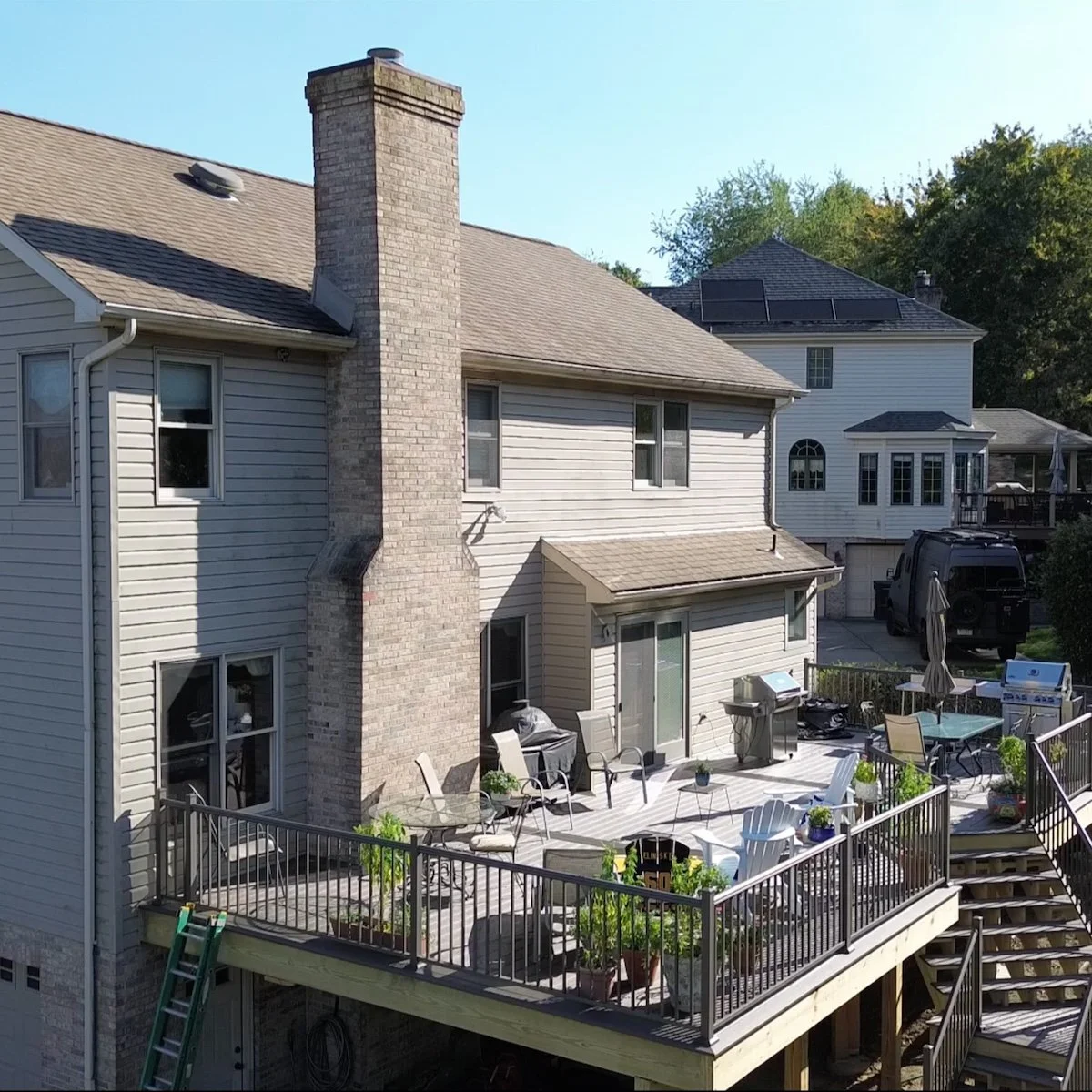 Grey House with open rear deck and handrail