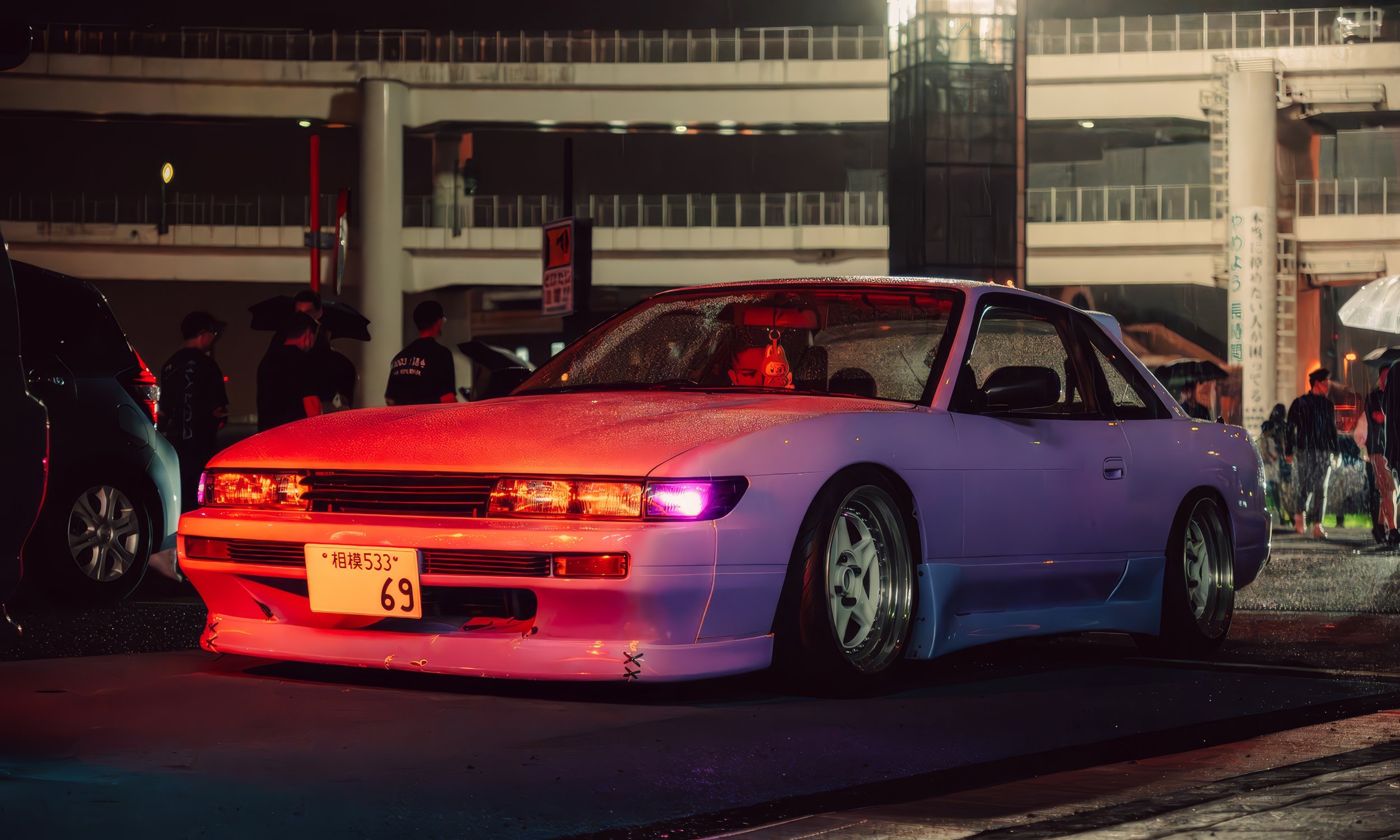 Un automóvil deportivo blanco con luces rosadas y doradas, estacionado en la calle en la noche, con un grupo de personas con paraguas en el fondo y un edificio de varios pisos.
