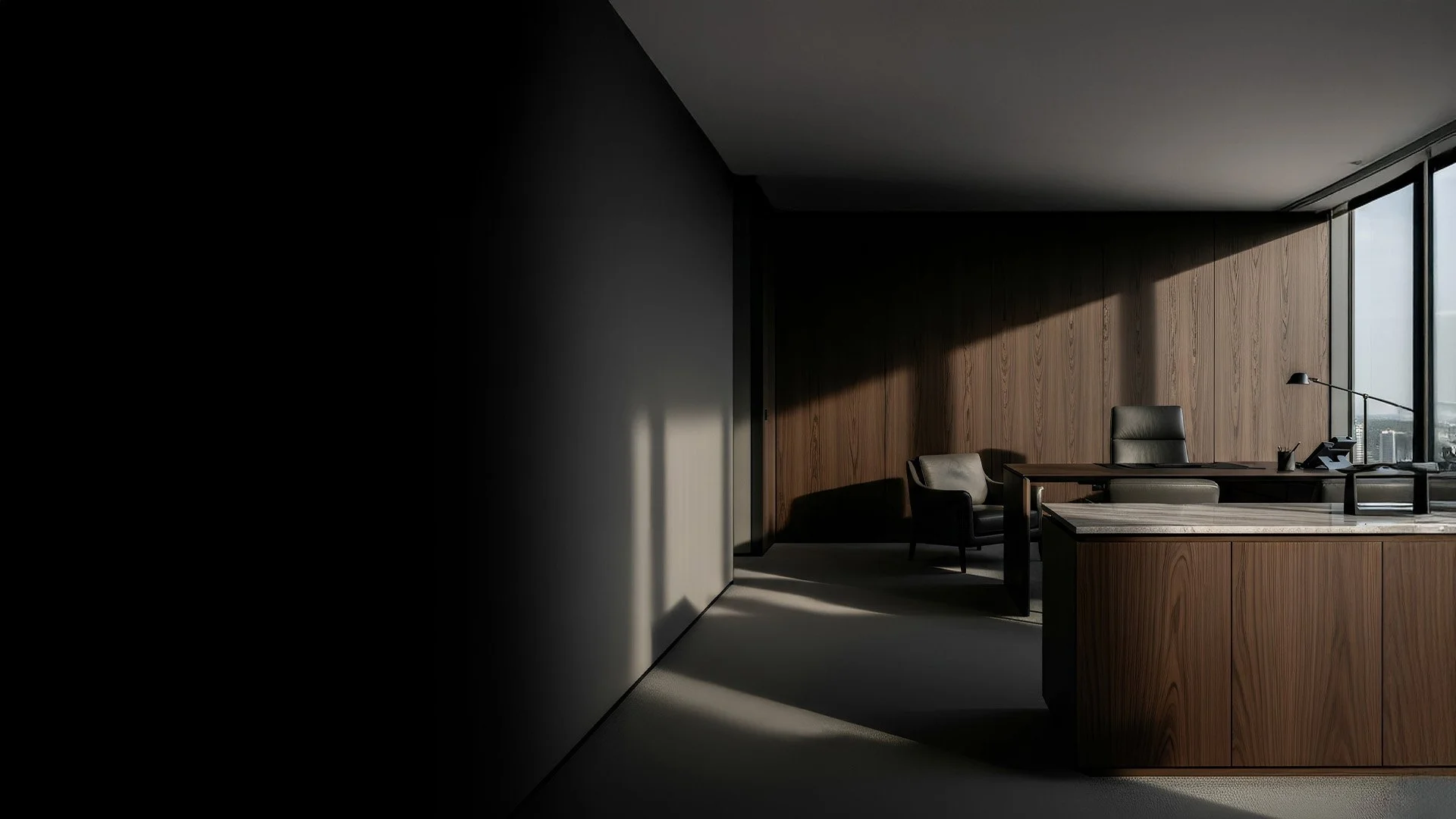 An office with a large window on the right, a wooden wall behind a desk, a black office chair, a small armchair, and a desk lamp in a dimly lit room with shadows cast from the window.