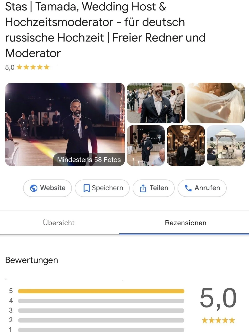 Screenshot von den Erfahrungen und Bewertungen von Tamada Stas als Bester Moderator deutschlands, er hält ein Mikrofon bei einer Hochzeitsfeier, umgeben von weiteren Gästen in formeller Kleidung, im festlich dekorierten Innenraum.
