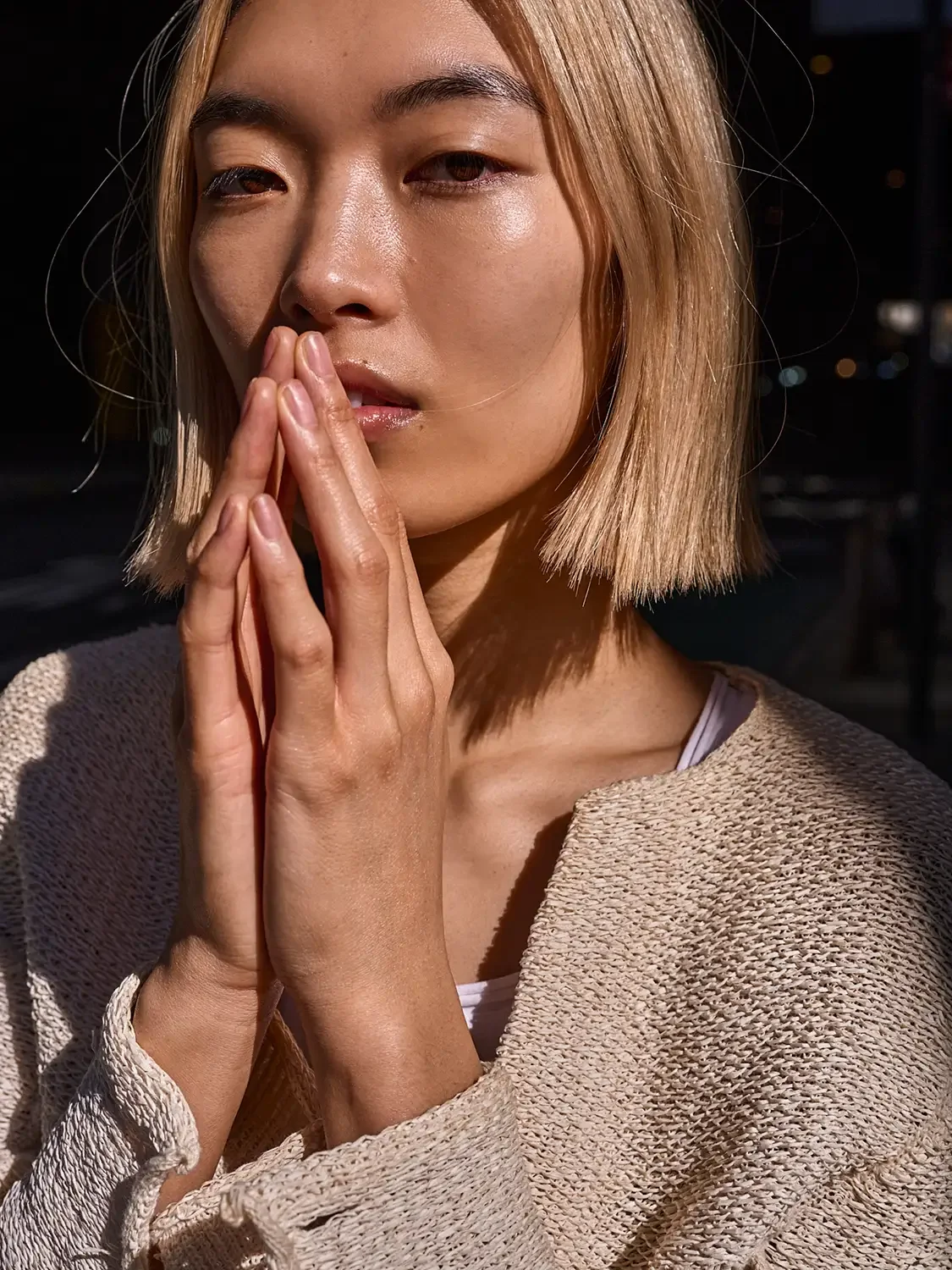 Asian woman with her hand up by her face