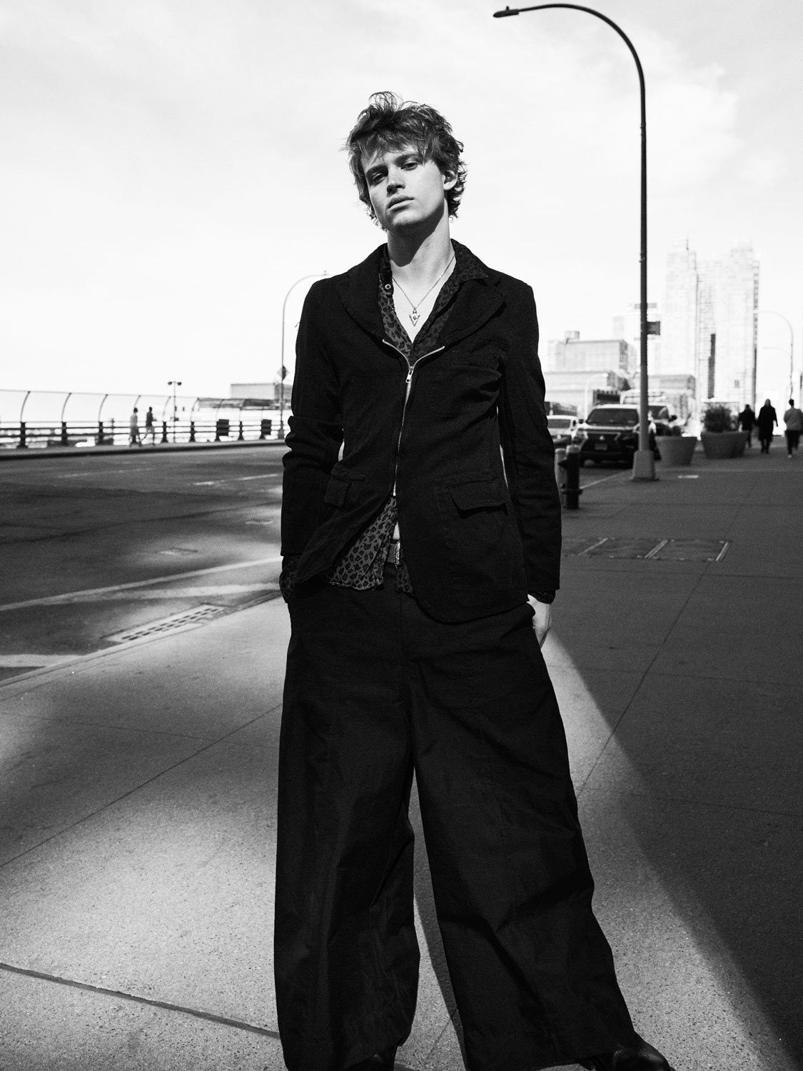 Black and White photograph of a young man in a dramatic street setting