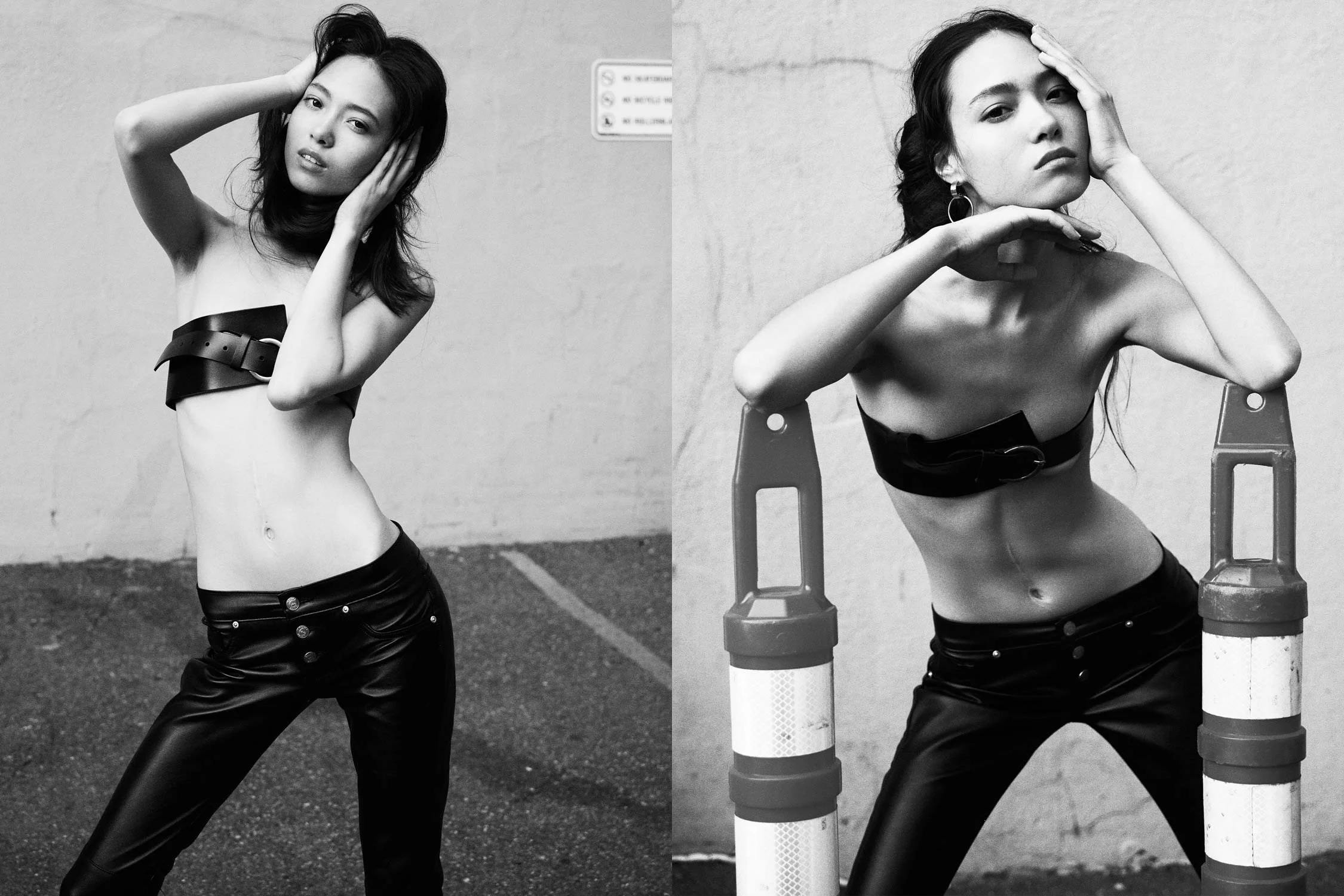 Black and white photograph of a young woman with dark hair, posing with her hands near her face. She is shirtless, wearing a wide belt and shiny leather pants, standing against a plain wall. The image is split into two, with the left side showing her