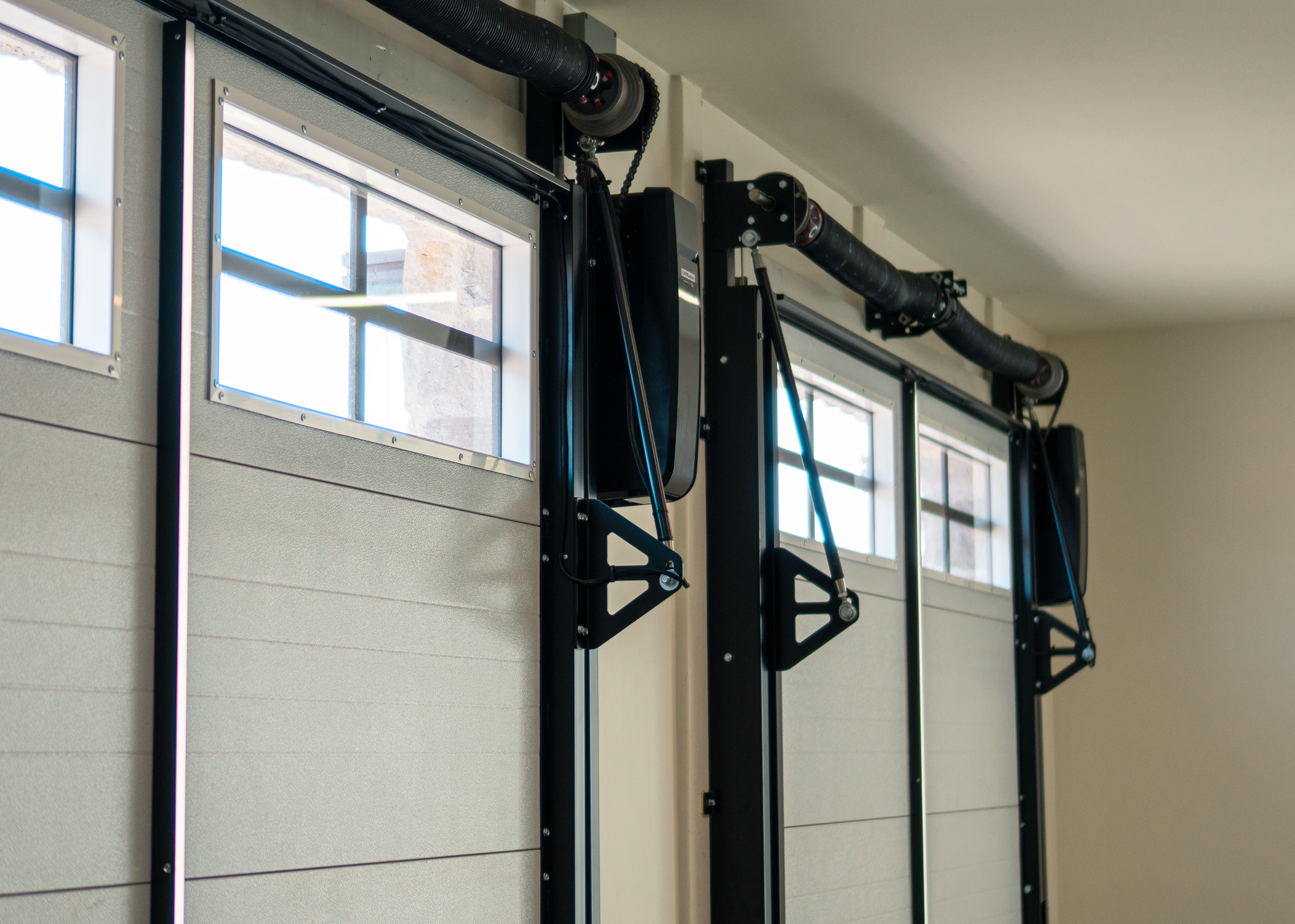 Industrial garage door with black pulley system and windows