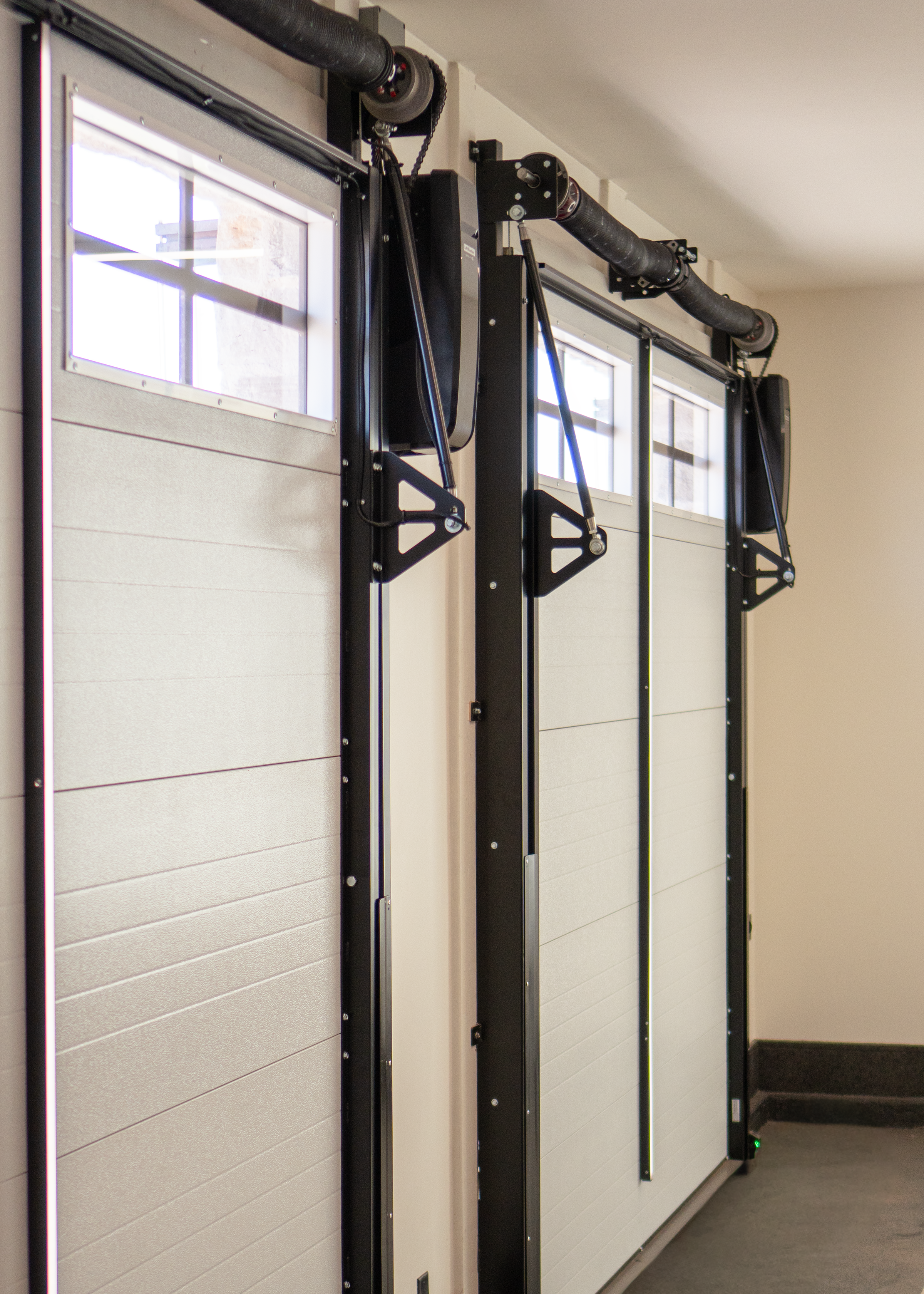 Clean trackless hardware system mounted on dual single car garage doors on a custom home.