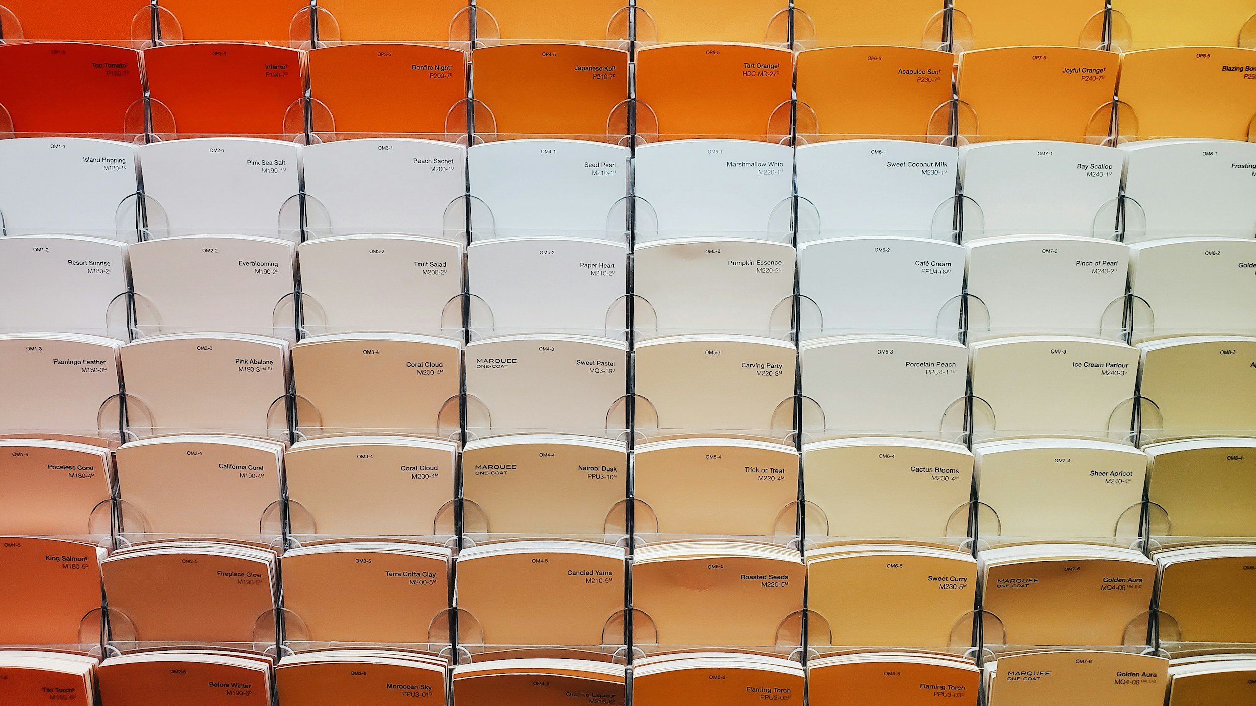 Display rack with color sample chips arranged from red to yellow shades.