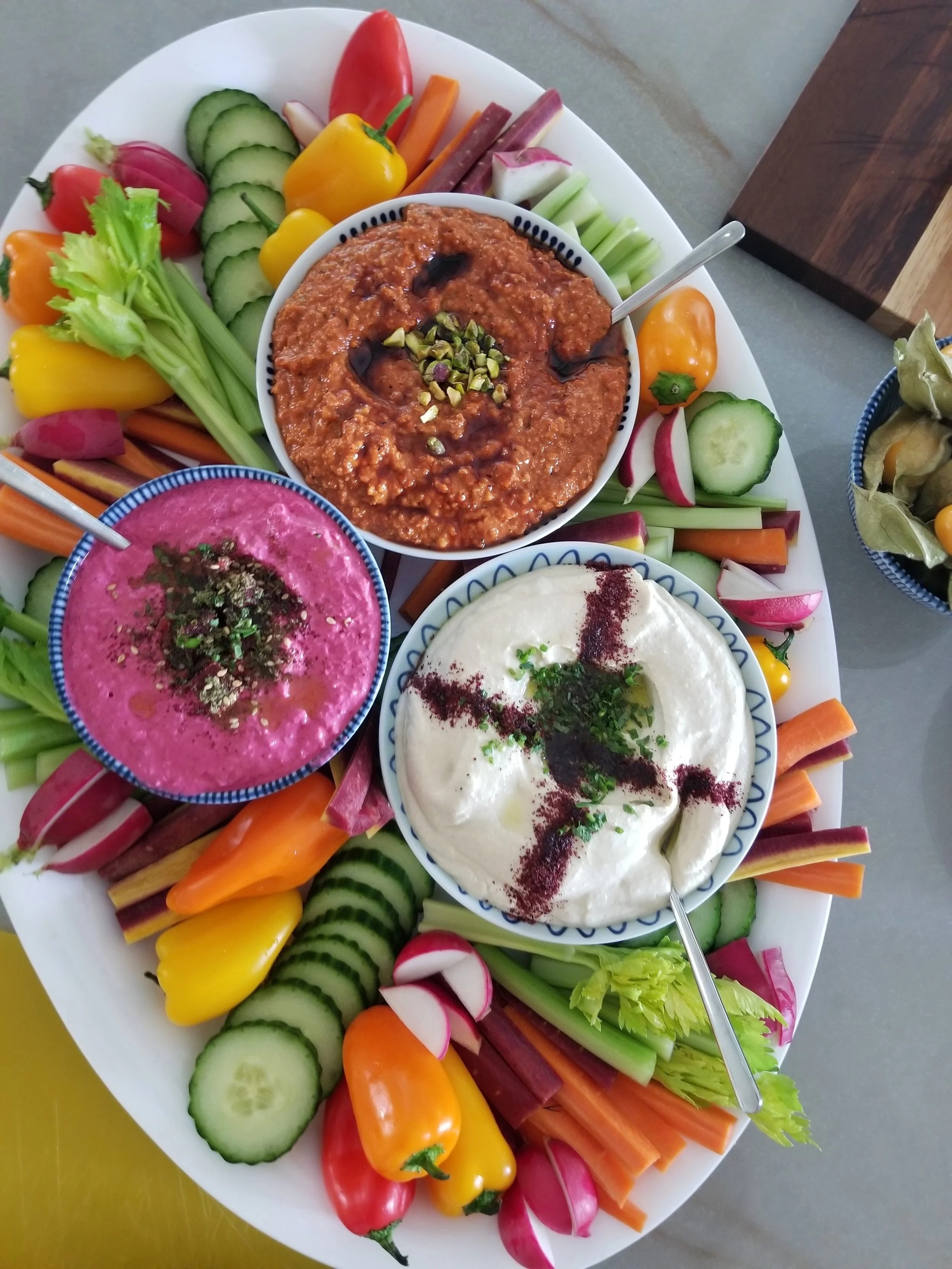 Collection of Mediterranean mezze with fresh cut vegetables alongside.
