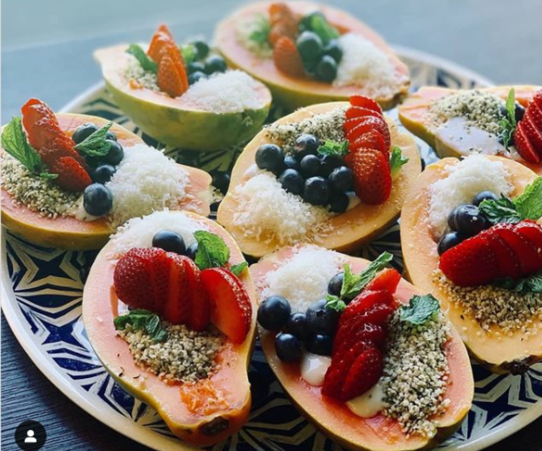 plate of figs cuts in half, topped with berries and coconut