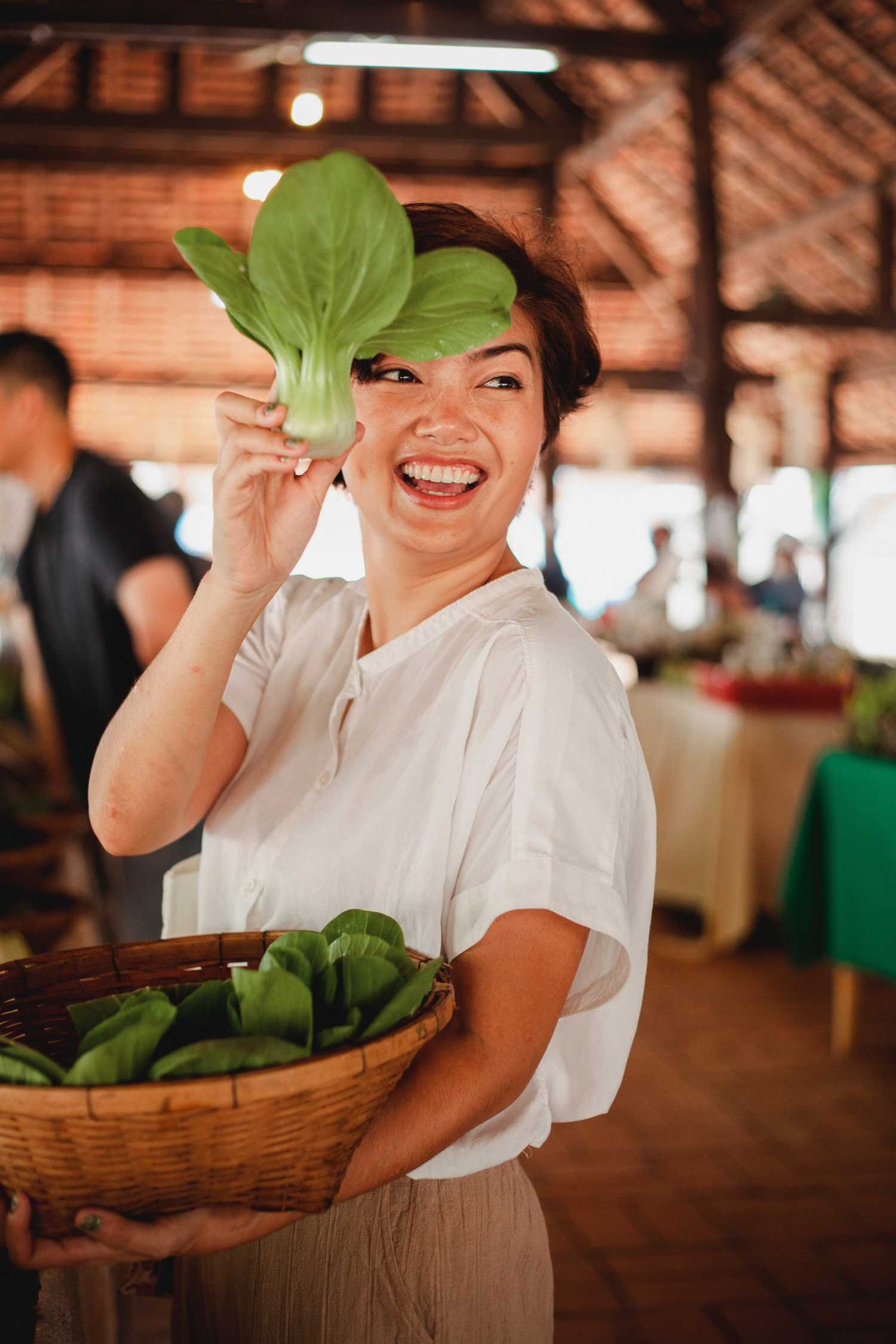 Chef holding a bunch of Bok Choy in her right hand