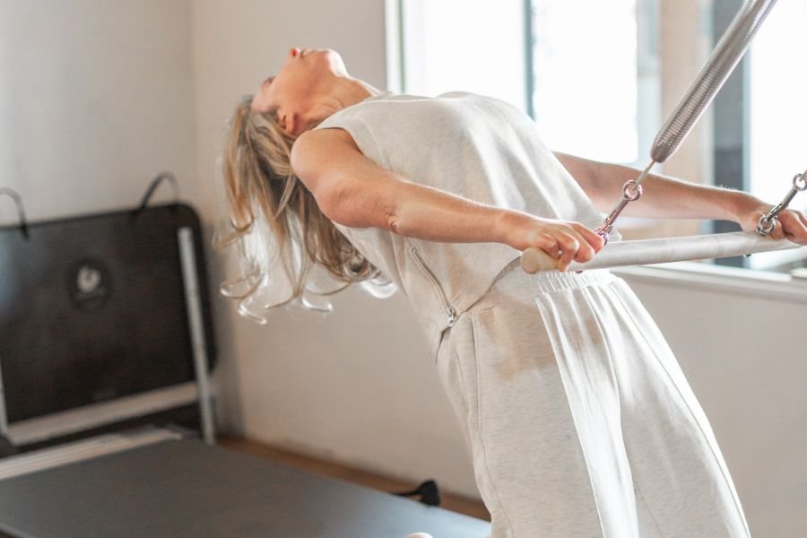 A woman doing physical therapy exercises on an inversion table in a rehabilitation room.