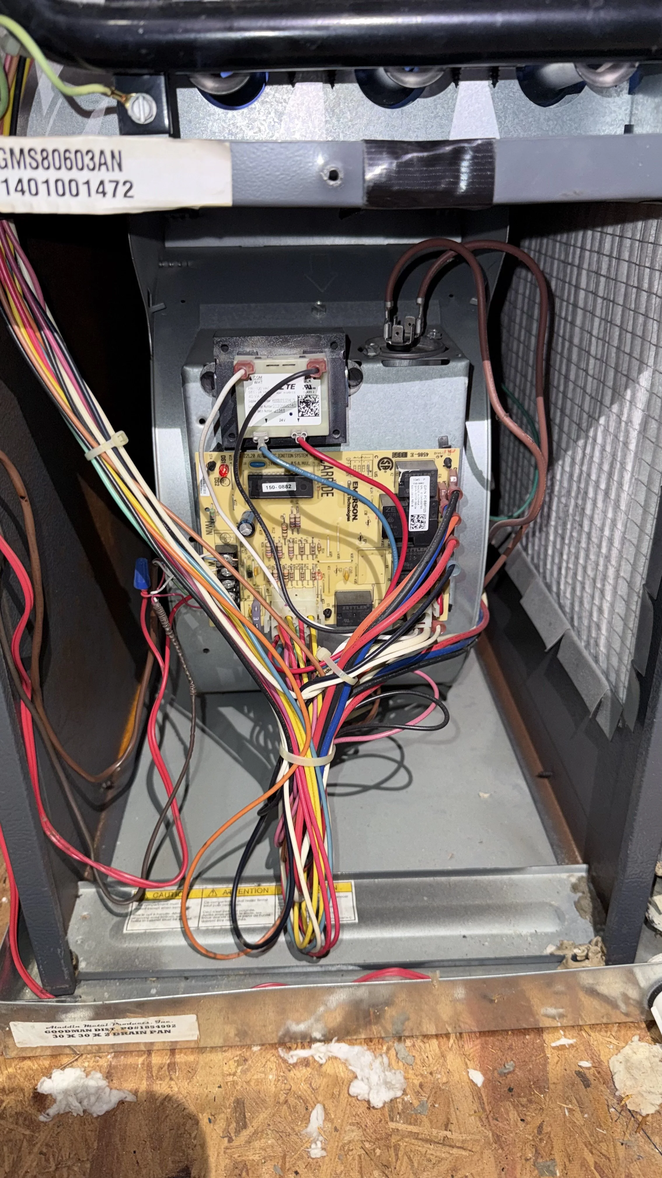 Open HVAC furnace with visible wires, circuit board, and internal components.