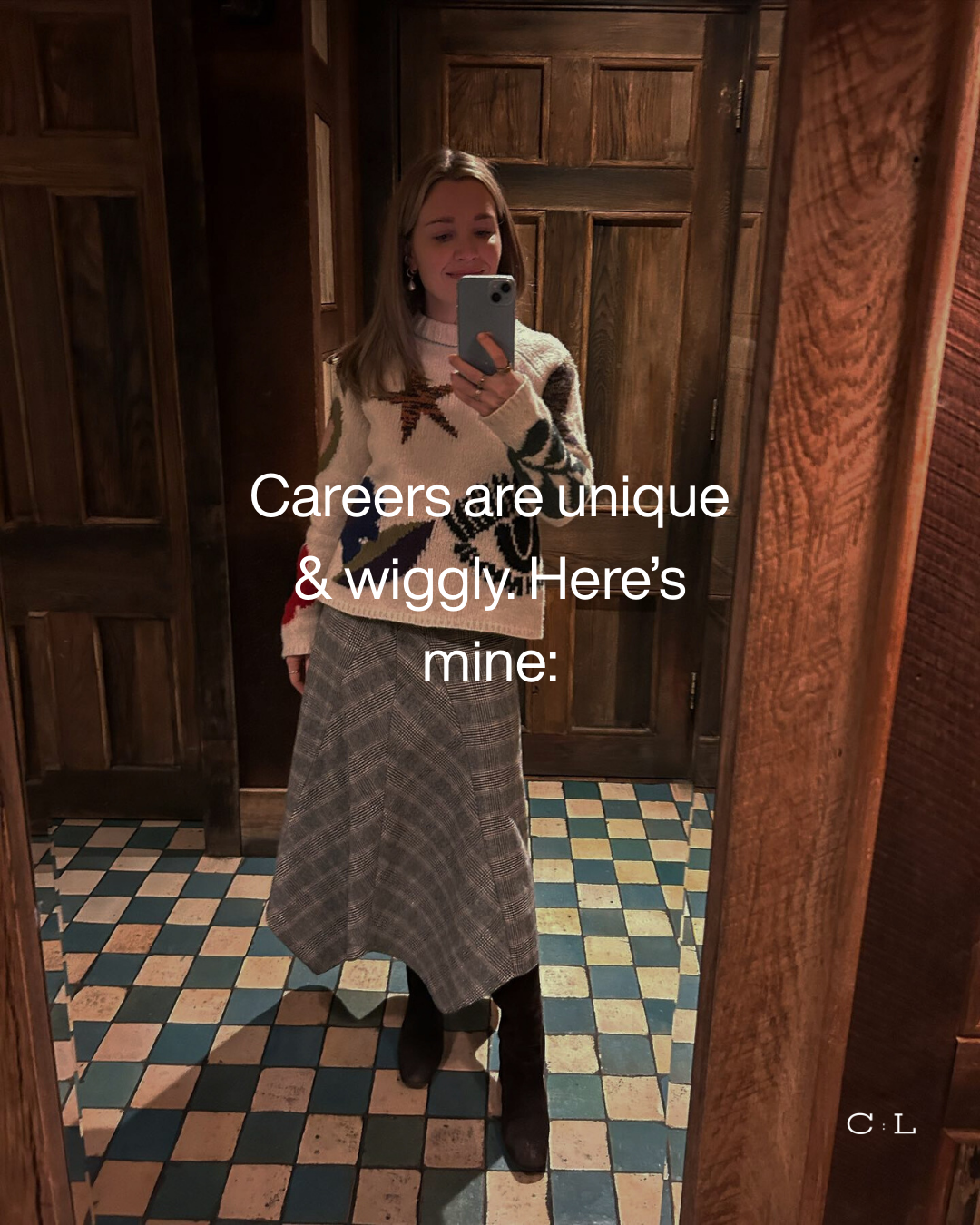 A picture of sarah, the director of Connected Luxe,  taking a mirror selfie in a wood paneled room. She is wearing an abstract patterned sweater and a plaid skirt, with black boots. The overlay text reads "Careers are unique & wiggly. Here’s mine:".