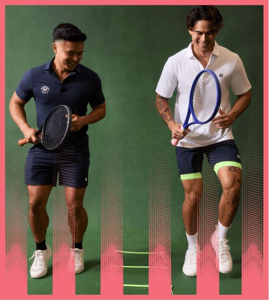 Two men playing indoor tennis using strike pads for agility training on a green backdrop.