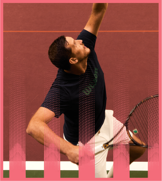Male tennis player in black shirt and white shorts preparing to hit a shot on a red tennis court.