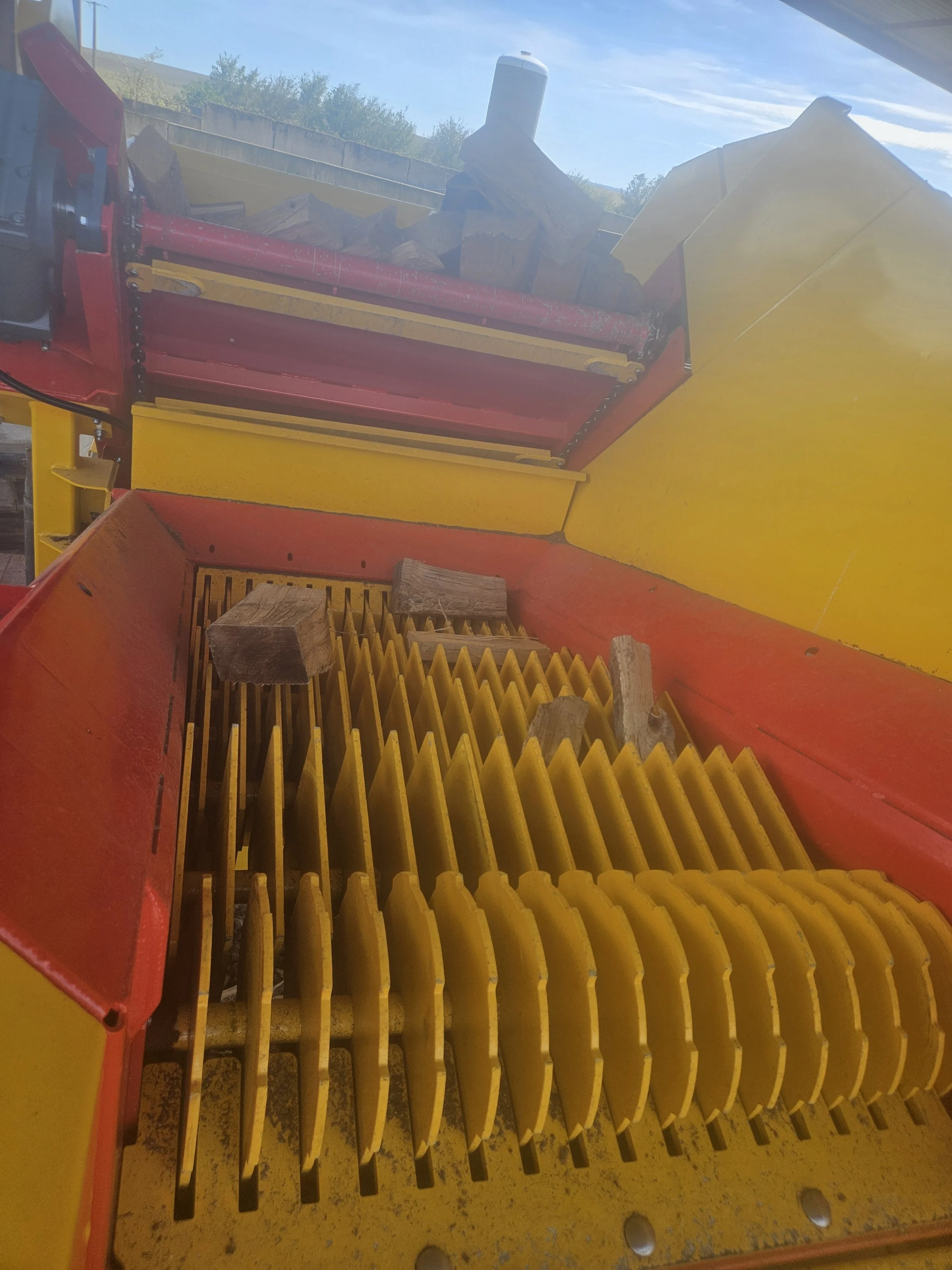 Une machine de coupe de bois, avec des morceaux de bois dessus et en dessous, pour nettoyer le bois