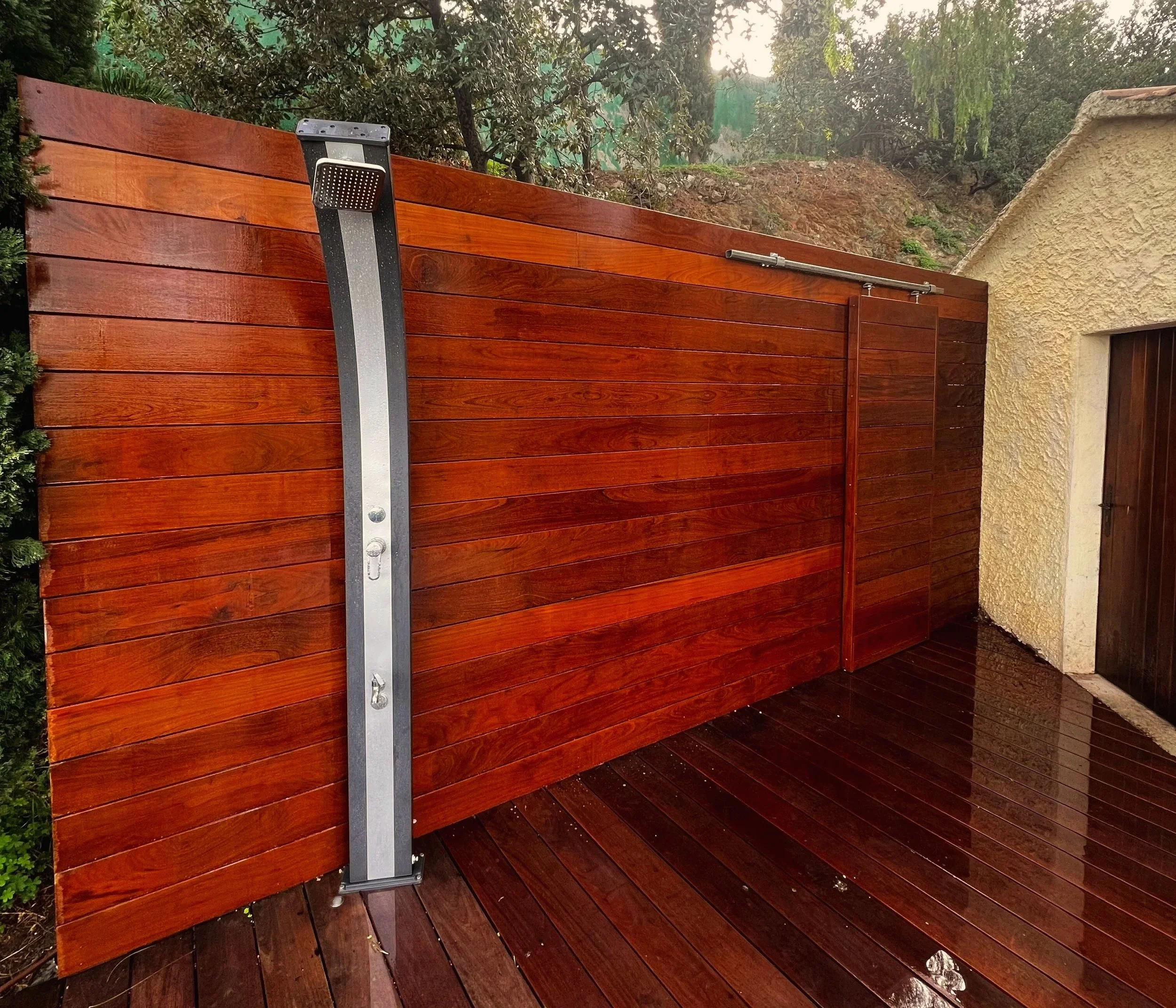 Claustra en bois extérieur - Douche extérieure en bois verni, création sur mesure par Art Design Créations.