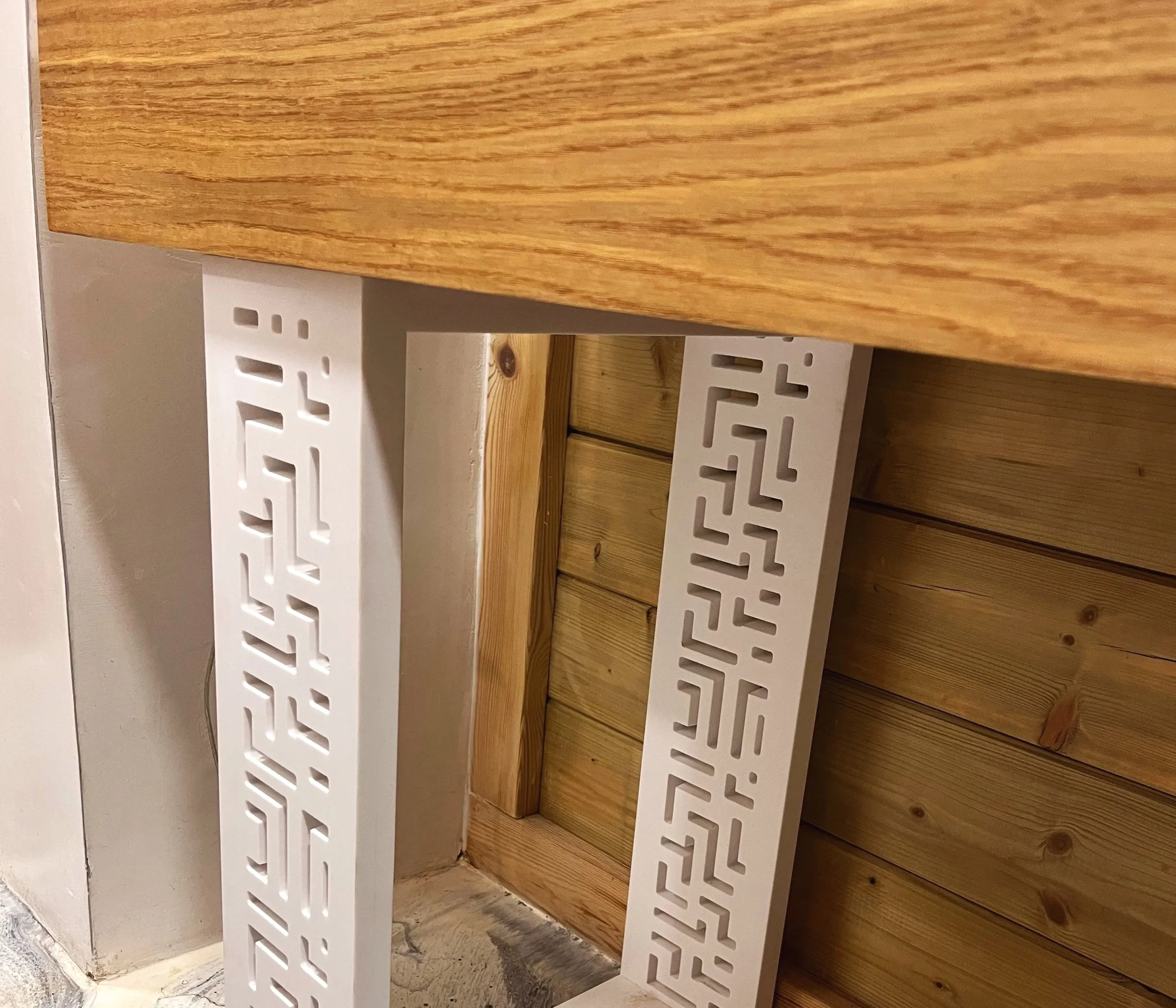 Photo d'un meuble en bois avec des détails de coupe décorative blanche.