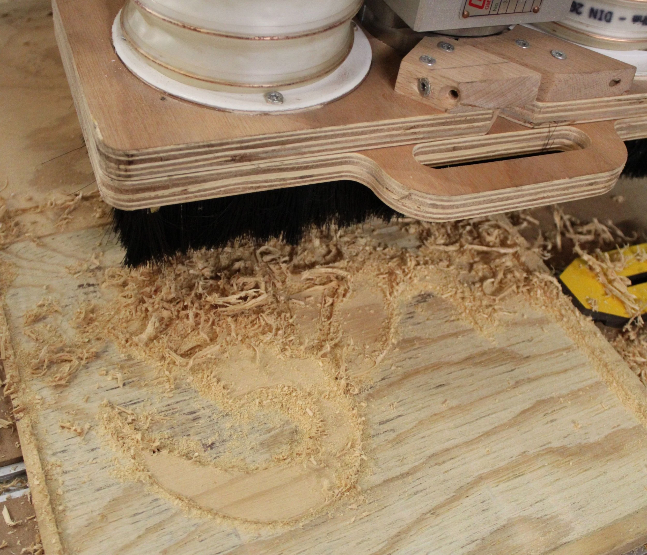 Outils de menuiserie avec une pièce en bois en cours de fabrication, garnie de copeaux de bois, sur un plan de travail en bois.