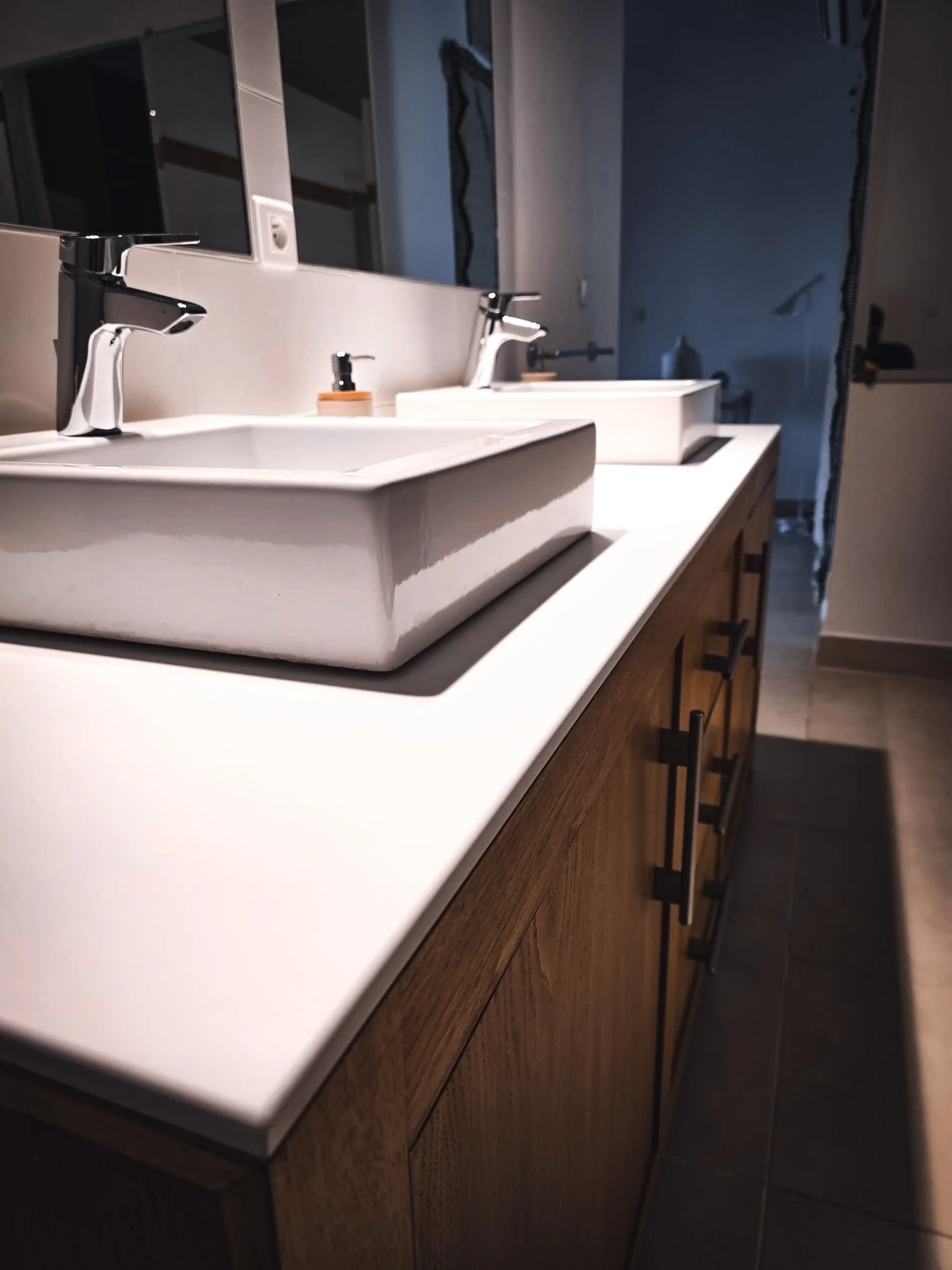Réalisation d'un plan de vasque en Corian® sur mesure à Bastia. Ce projet de salle de bain associe la qualité du Corian®, des lignes épurées et un agencement personnalisé pour un rendu moderne et intemporel.