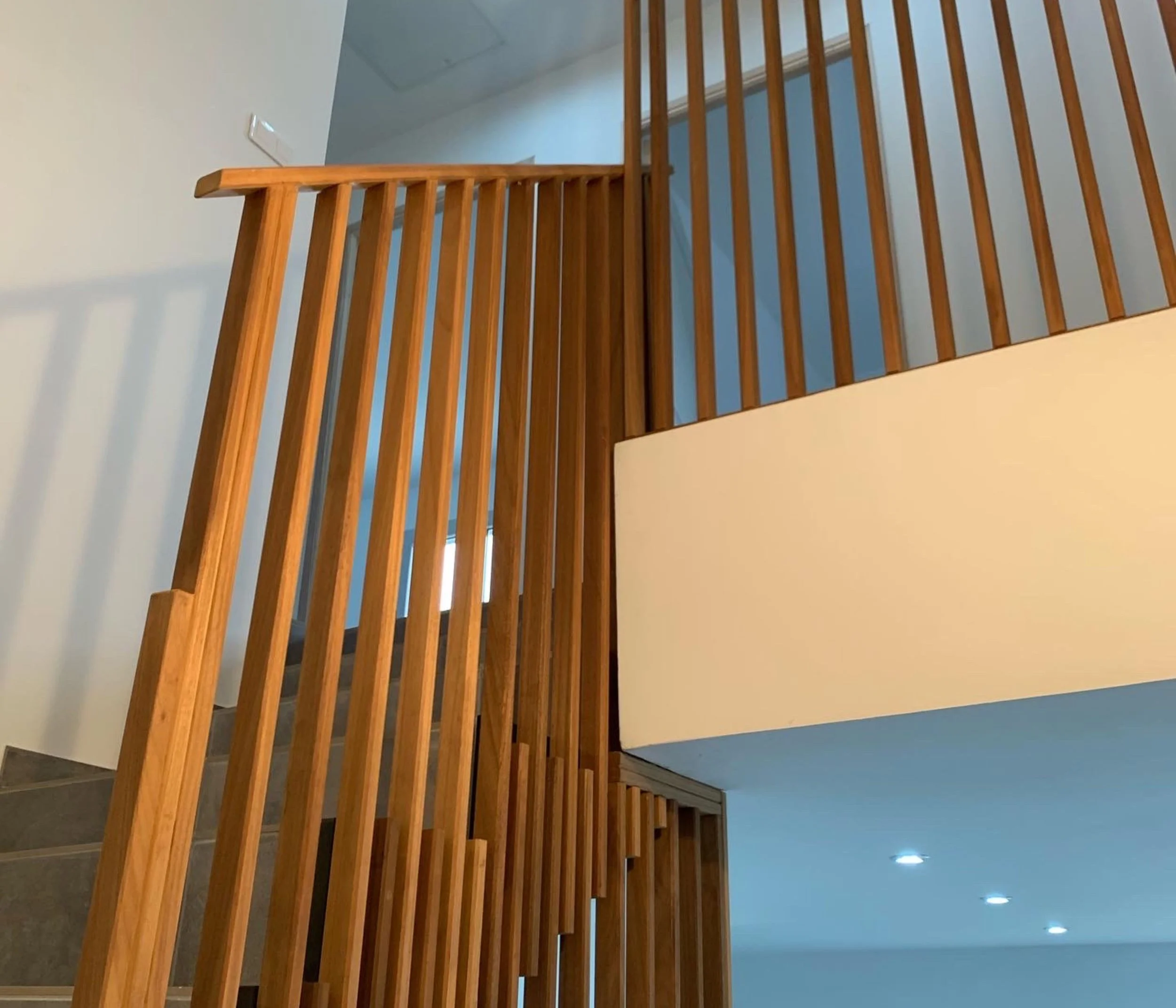 Escalier en bois avec barrières en bois et espace intérieur moderne.