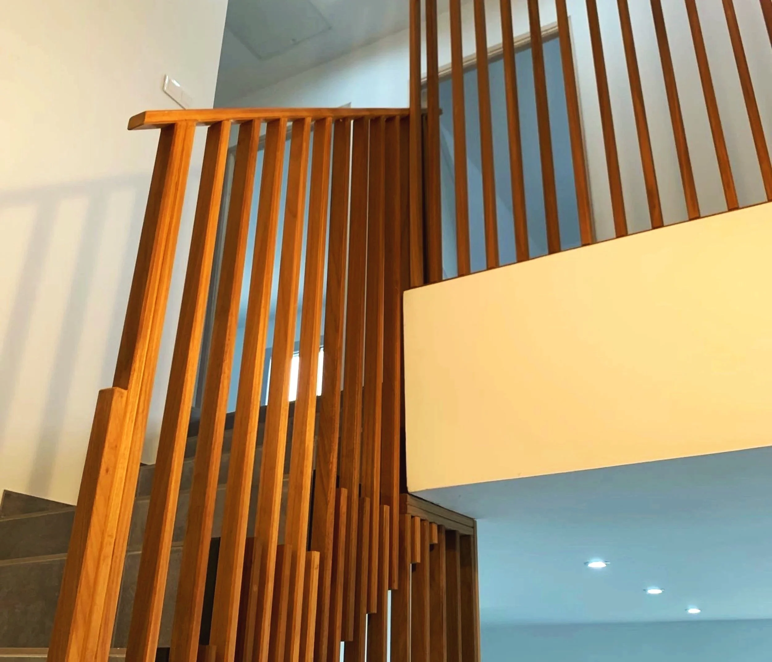 Escalier intérieur en bois massif avec rampe verticale, création artisanale élégante et épurée.