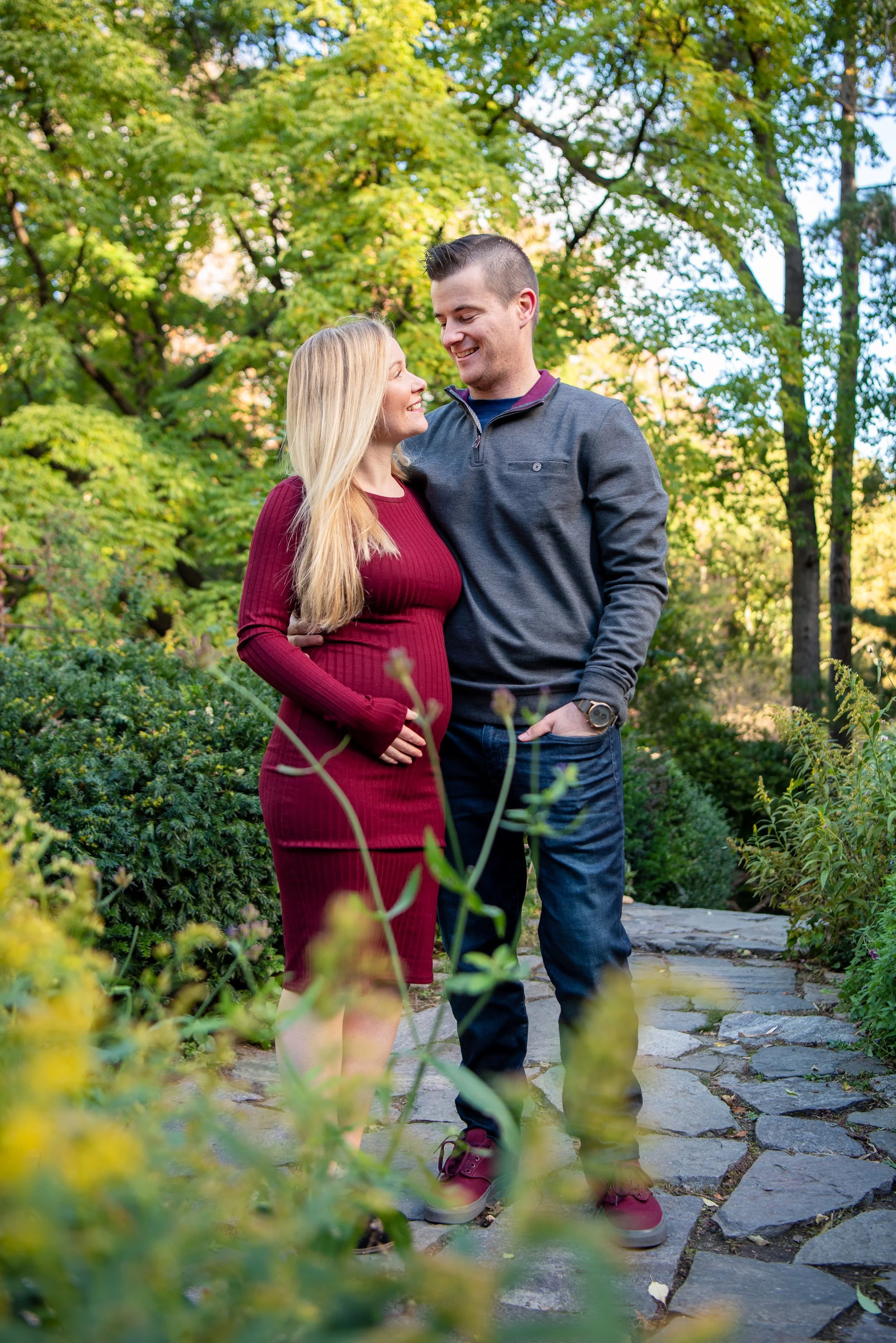 A couple smiling at each other, surrounded by flowering plants at Shakespeare Garden in Central Park