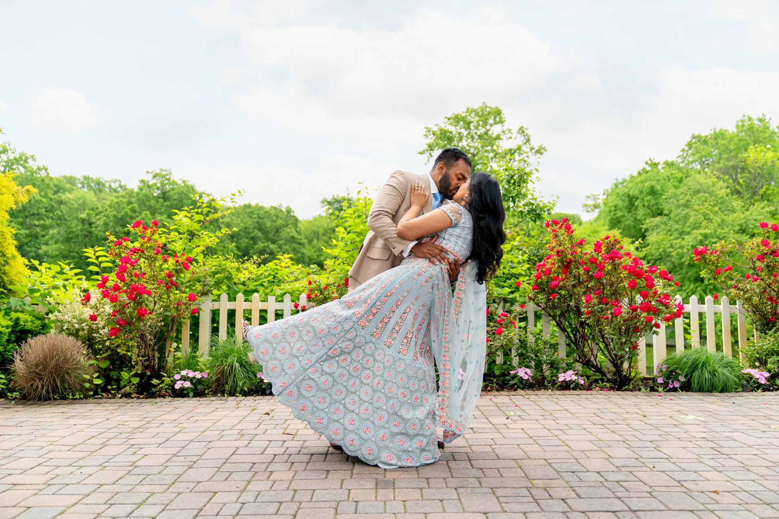 A man in a tan suit dipping a woman in a traditional Indian lehenga while kissing her

Staten Island engagement photographer
