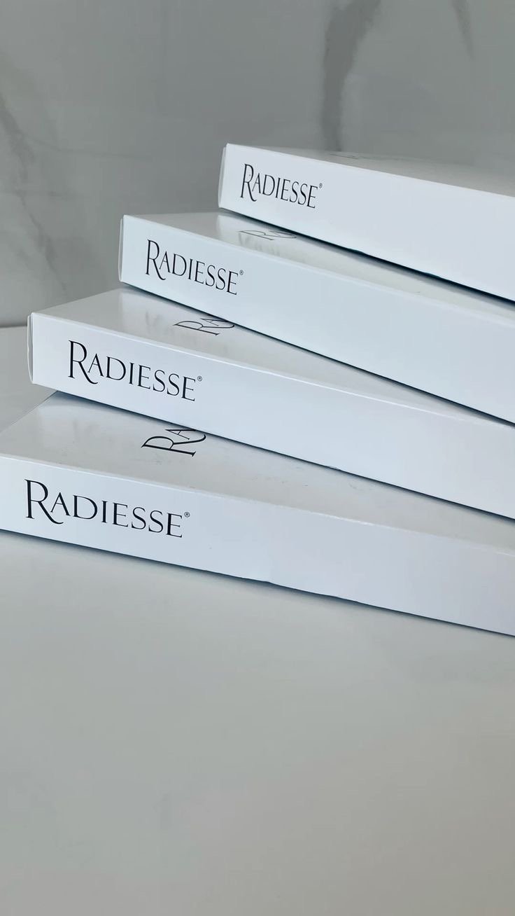 Four stacked white boxes labeled 'Radiesse' on a white surface, against a light-colored background.