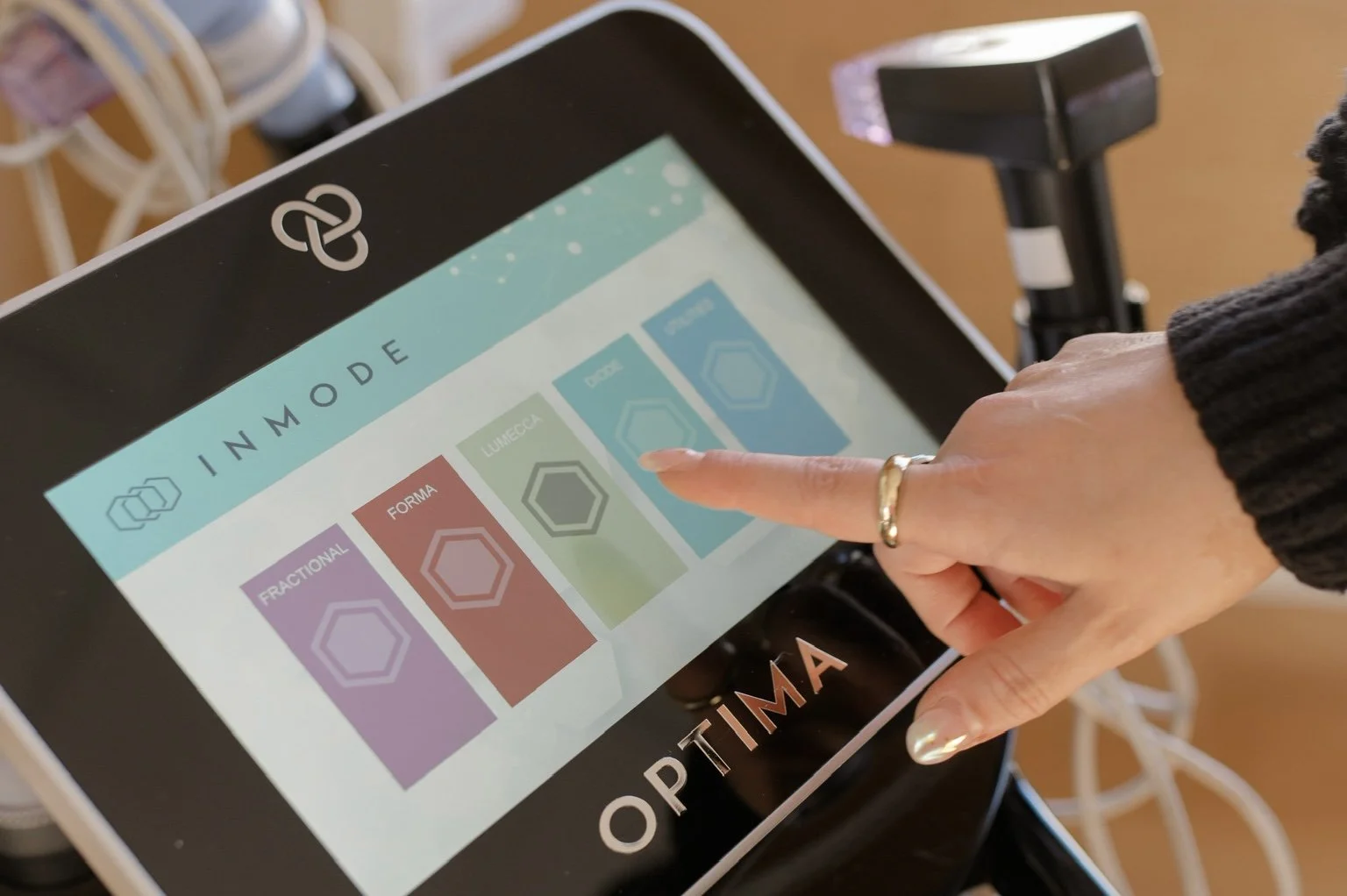 Touchscreen interface displaying different lighting modes labeled 'Fractional,' 'Forma,' 'Lume,' and 'Hex' with a person's finger pressing the 'Hex' mode.