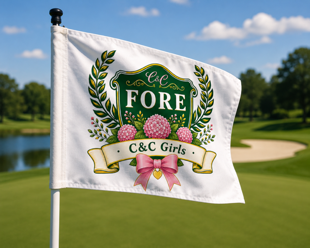 Golf flag with floral design and banner reading 'C&C Girls' on a golf course.
