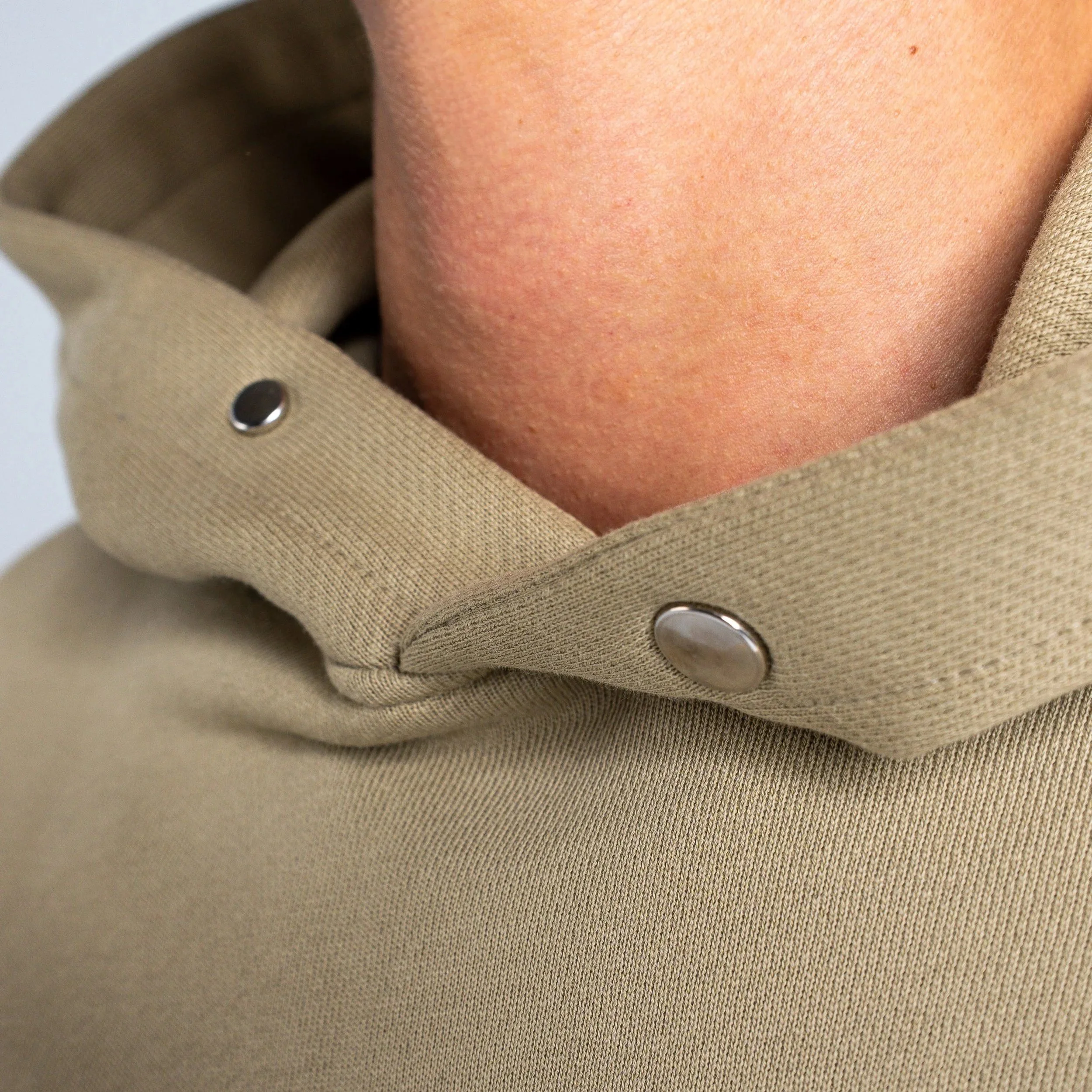 Close up of Heavyweight 100% French Terry cotton hoodie, with oversized fit and stiff hood. Metal snap buttons attached to the hood.