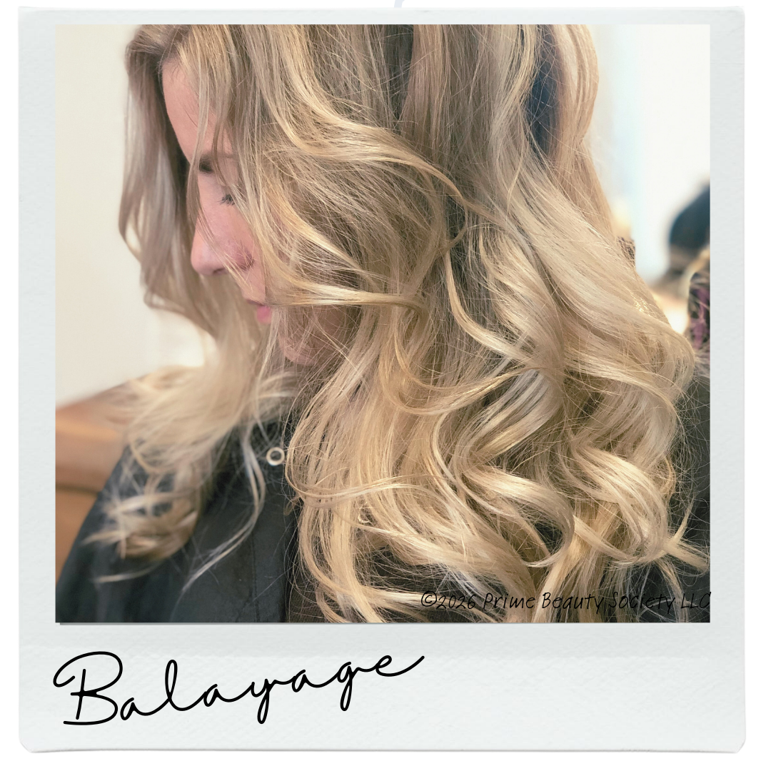 A woman with long, blond, curly hair looking down, wearing a black top.