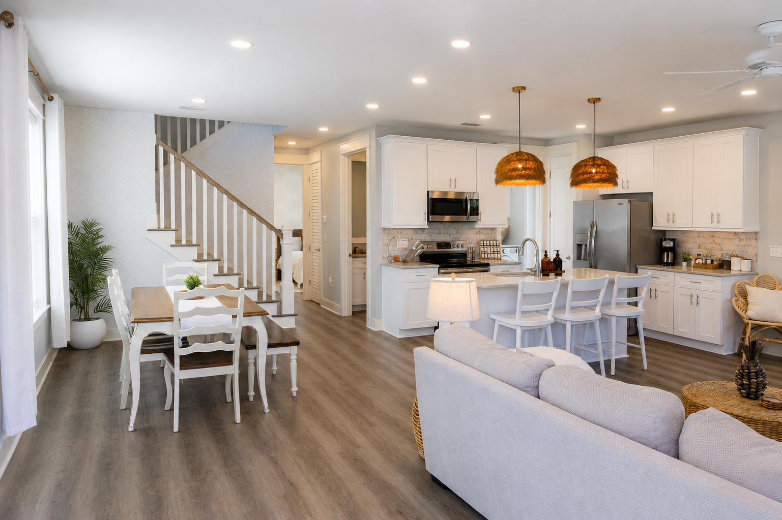 Bright open-concept living and dining area at Second Set with a comfortable sofa, dining table, white coastal cabinetry, and warm natural light.