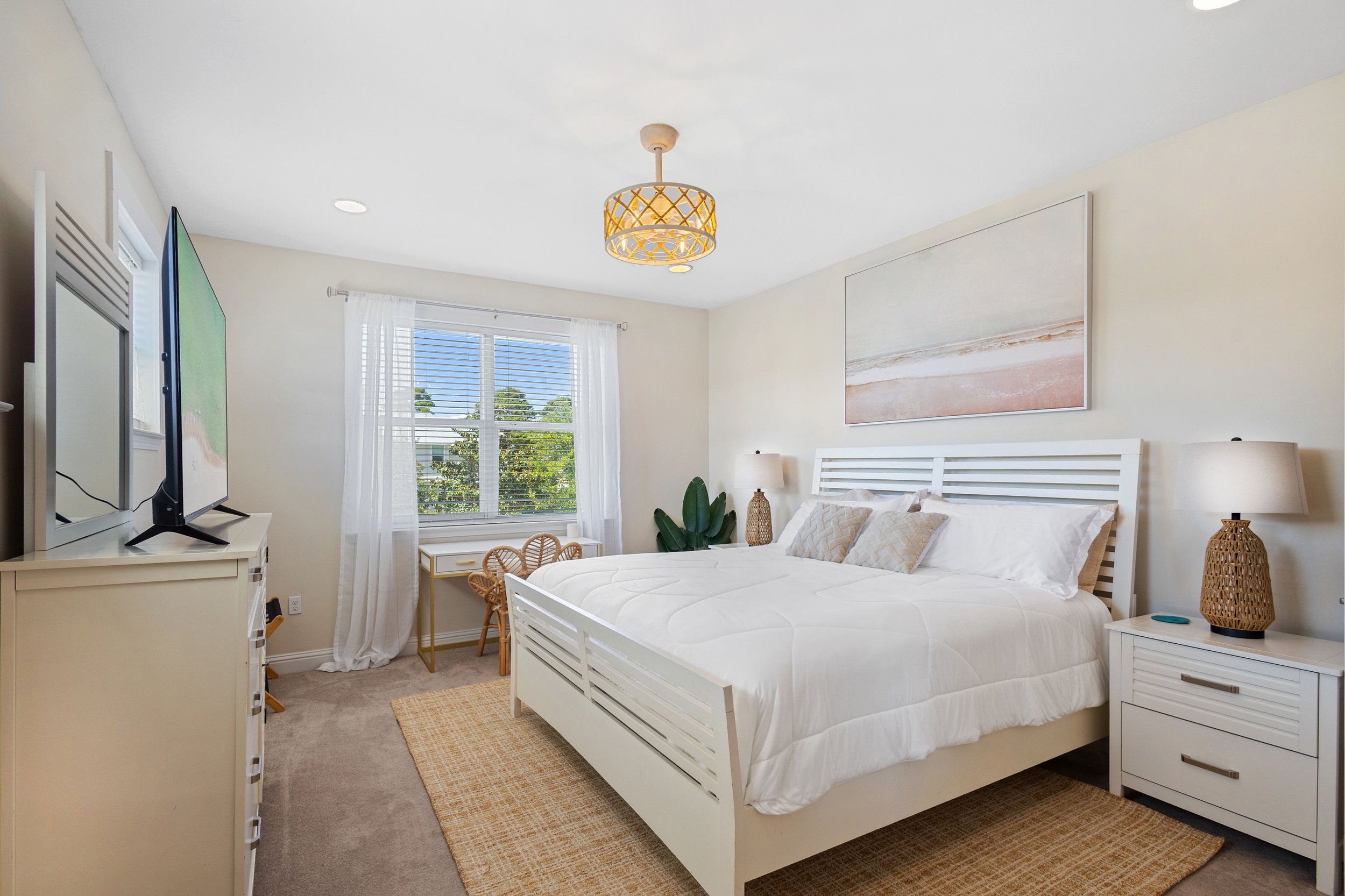 King bedroom at Salty Surf on 30A with coastal-inspired decor, comfortable bedding, natural light and a private en-suite bathroom