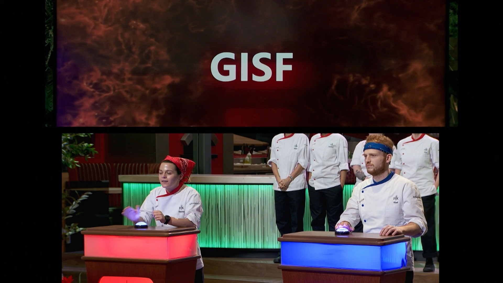 Two contestants on a cooking competition game show, each at a podium with illuminated panels, facing each other, with team members in chef uniforms standing behind them. The top part displays the word 'GISF' on a fiery background.