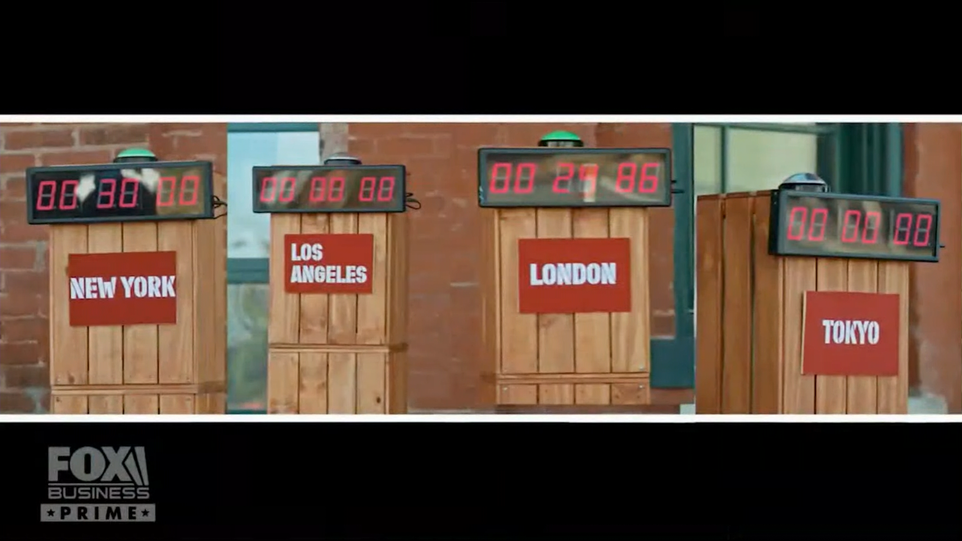 Four digital countdown clocks on wooden stands labeled with city names: New York, Los Angeles, London, and Tokyo, with the London clock showing 00:25:86 and the others showing 00:00:00. The Fox Business Prime logo is in the lower left corner.