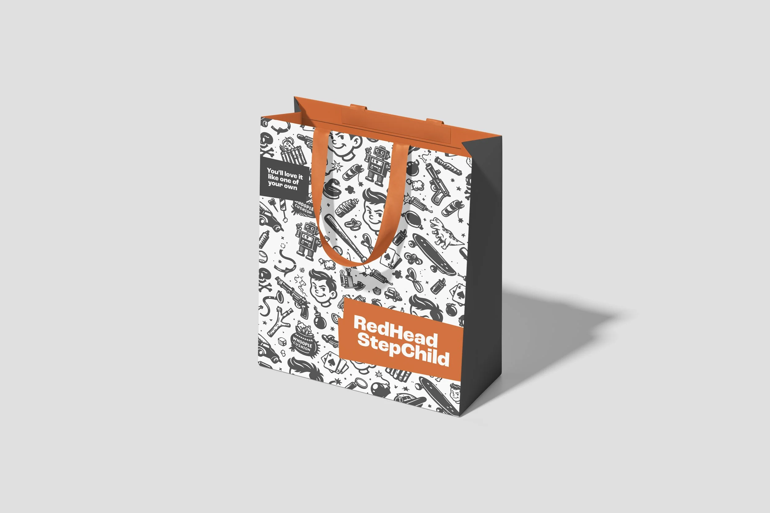 Shopping bag with black and white toy-themed illustrations, orange accents, and the text "RedHead StepChild"