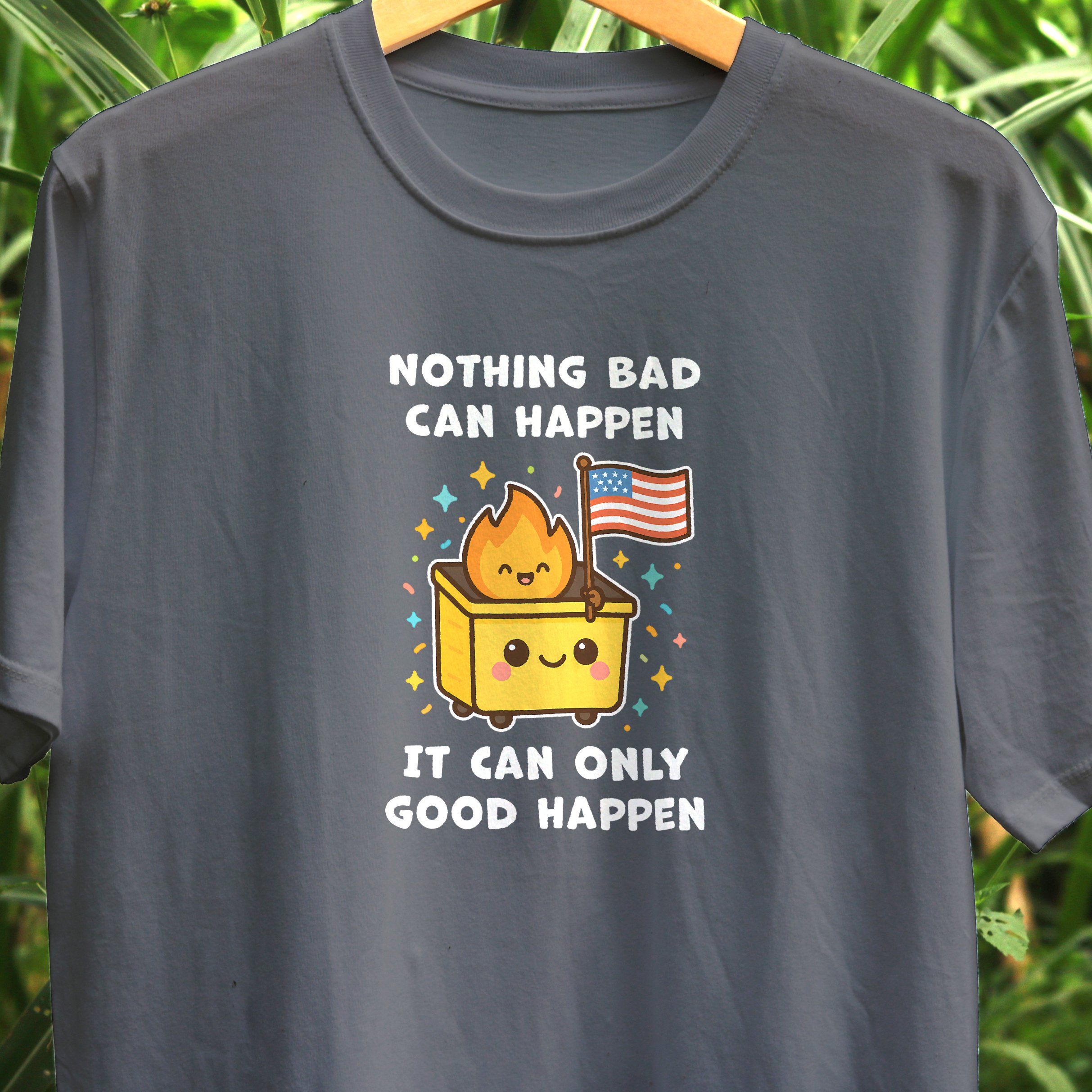 Gray T-shirt with a cartoon graphic of a happy box with a smiling flame character on top holding an American flag, surrounded by colorful stars, with text that reads 'Nothing bad can happen, it can only good happen.'