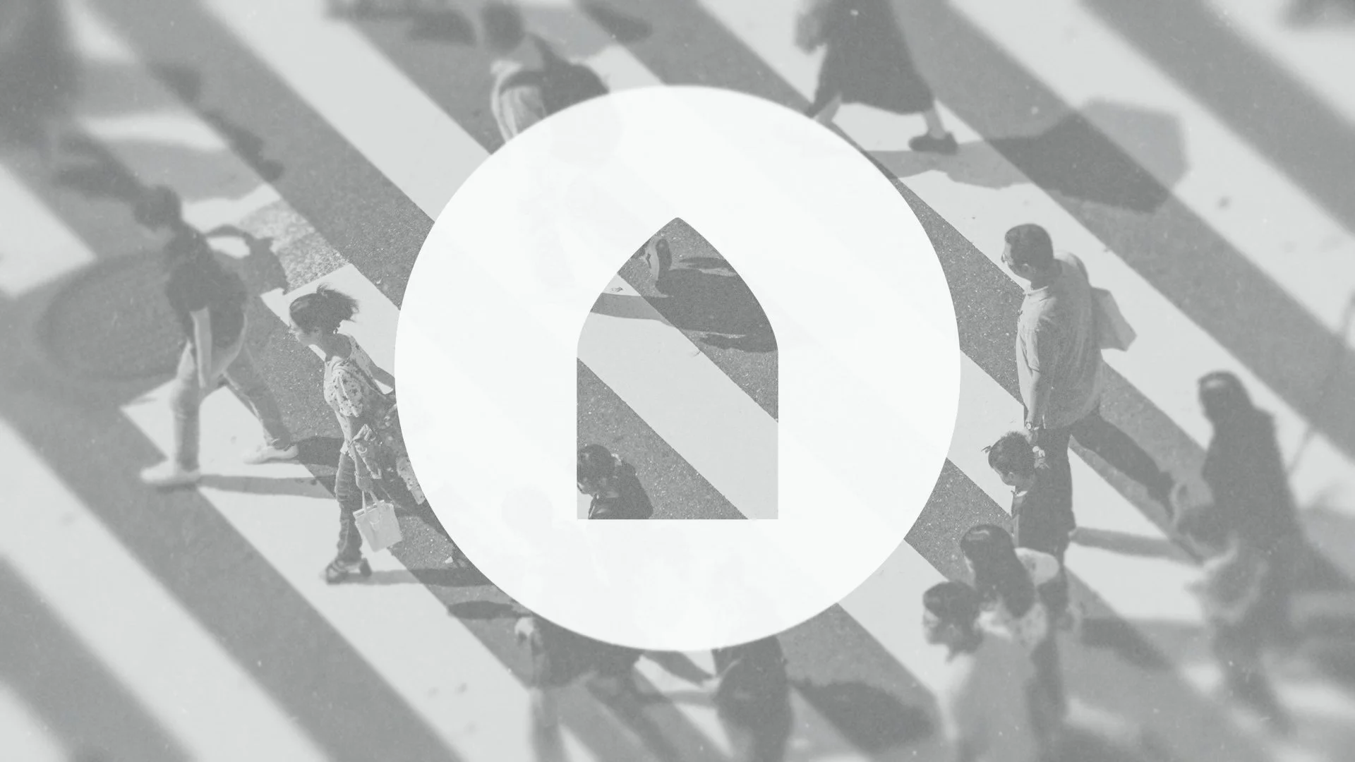 People crossing a street on crosswalks, seen from above, with a large white icon of an upward arrow in a circle overlaying the image.