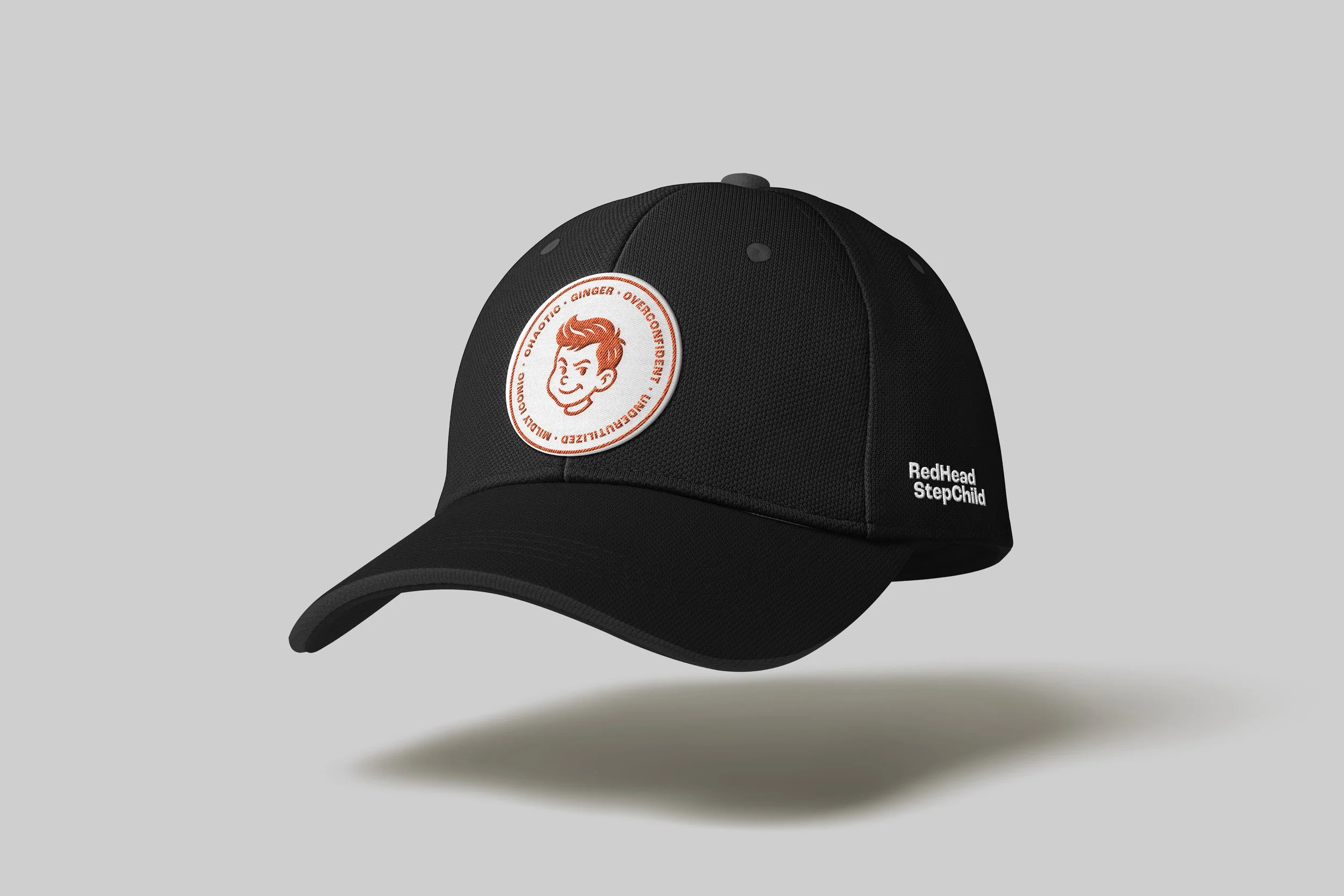 Black baseball cap featuring a circular patch with a cartoon face and red text, and the words "RedHead StepChild" embroidered on the side.