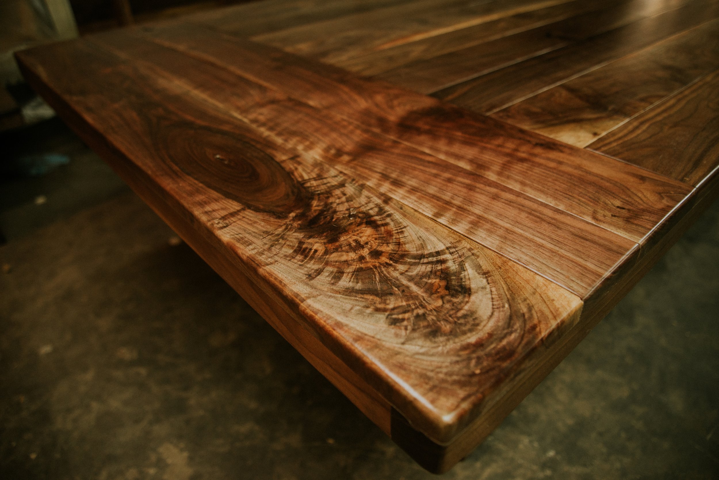 Close-up of polished wooden table with visible wood grain and knots.