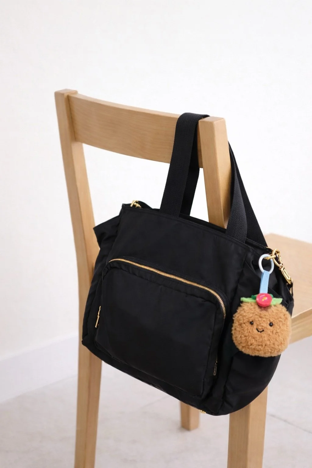 Stinky Tofu Bag Charm on black bag and chair