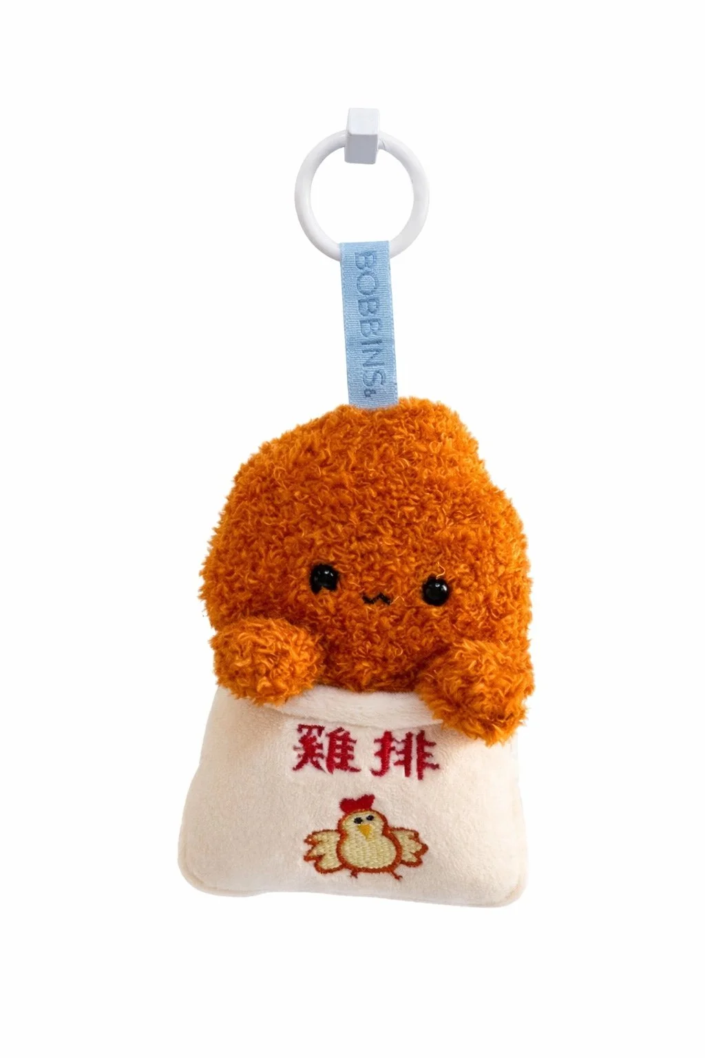 Fuzzy orange-brown Ji Pai plush keychain in white “雞排” bag with embroidered chicken, cute eyes, 3-shaped smile, white hood ring, and blue bobbins& label.