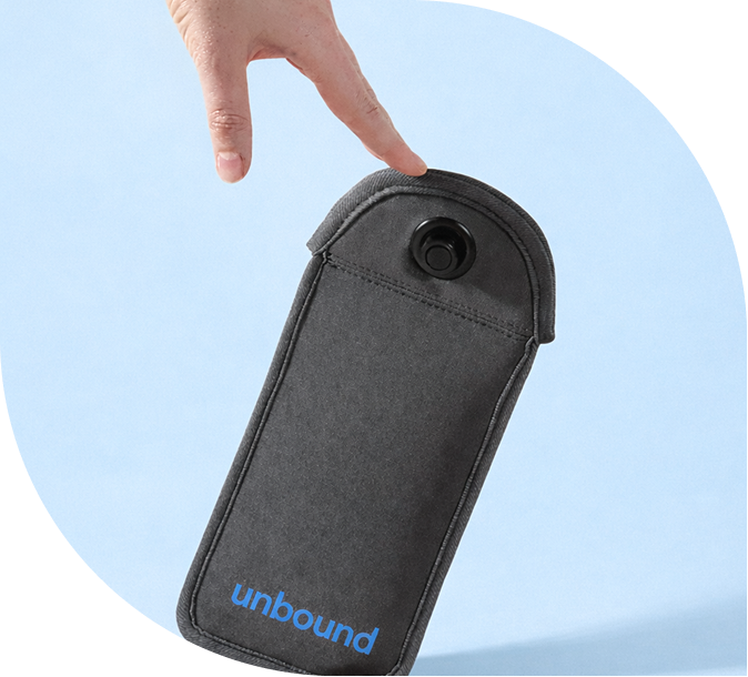 Close-up of a person's hand holding a black portable device with a camera lens on top and the word 'unbound' printed in blue on the bottom, against a blue background.