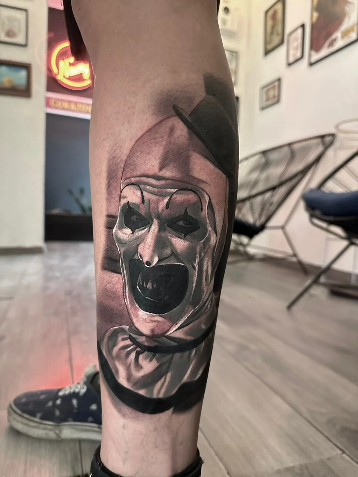 Tatuaje realista técnica black and grey representación en primer plano realista del payaso Art de la pelicula de horror terrifier, trabajo en sombras y texturas realizado en la navaja tattoo uno de los mejores estudios de tatuajes en ciudad de mexico