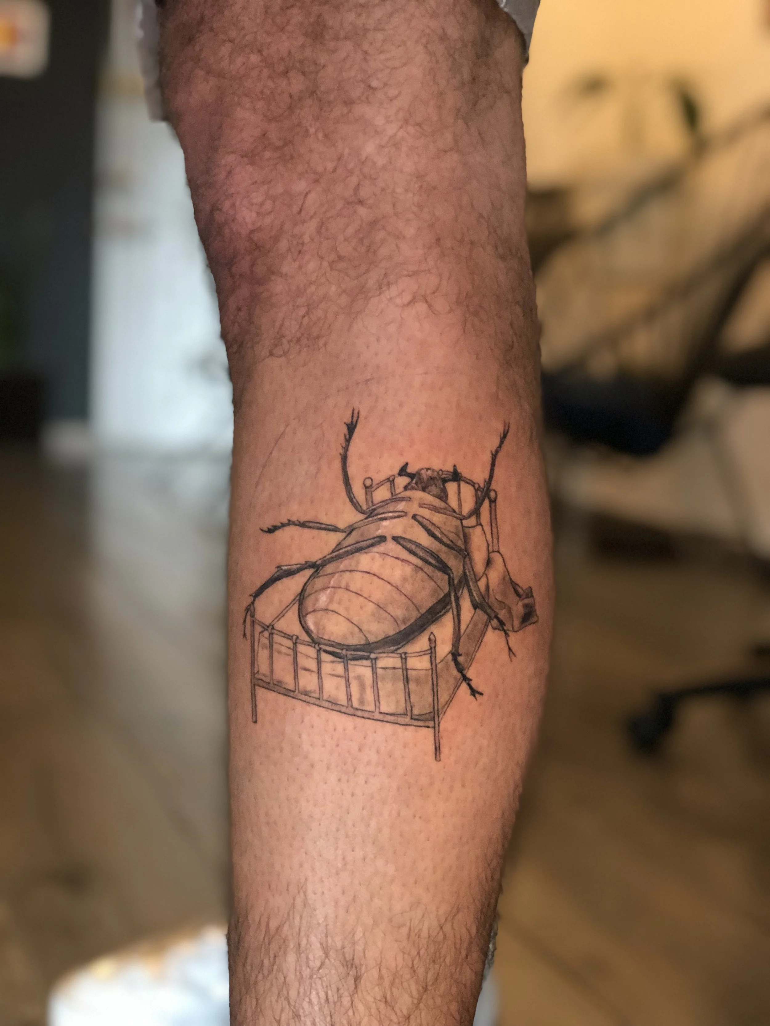 Tatuaje estilo fine line inspirado en el arte del libro la metamorfosis de kafka, recostado en una cama excelente tatuaje realista en grises y negros