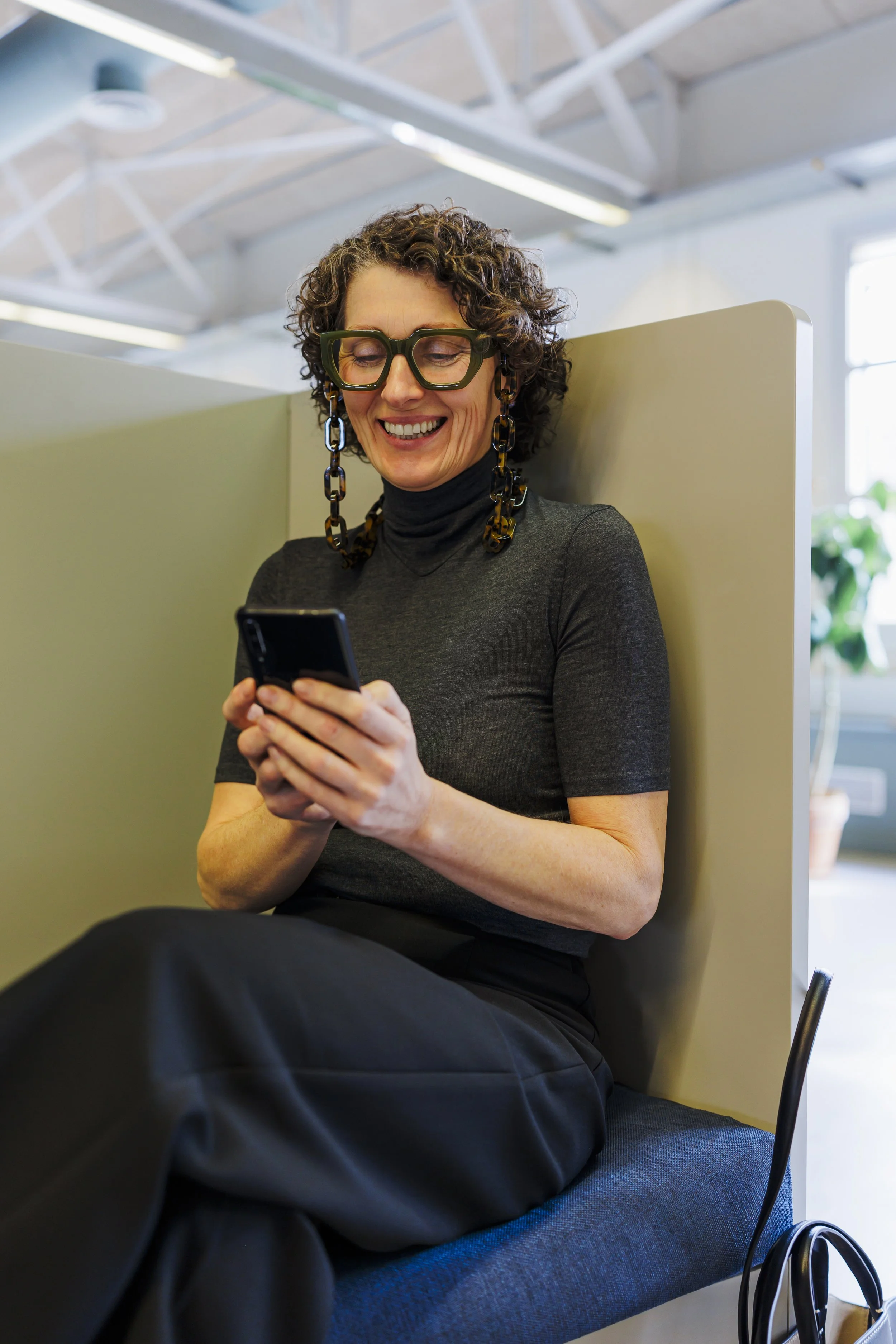 Women smiling and chatting with someone at her phone.