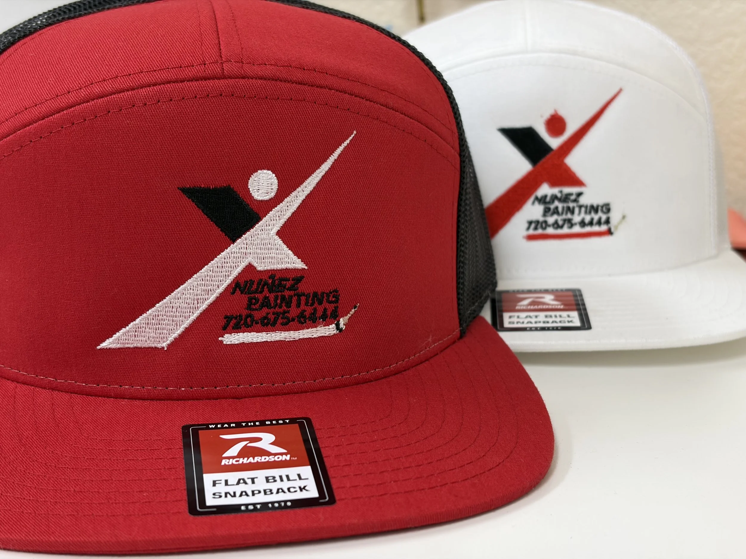 Red and white Richardson flat bill snapback cap with embroidered logo.